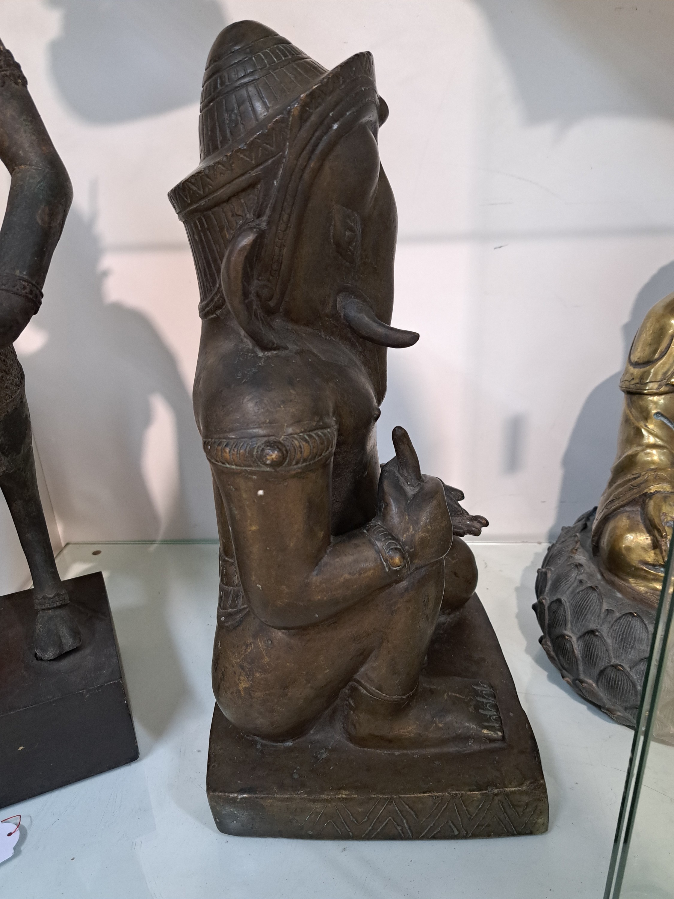 Detail g: Große Bronzefigur, Ganesha, Khmer-Stil, wohl 19. Jh., kniende Darstellung, in einer Hand Shankha (Muschel) in der anderen Hand den abgebrochenen ...