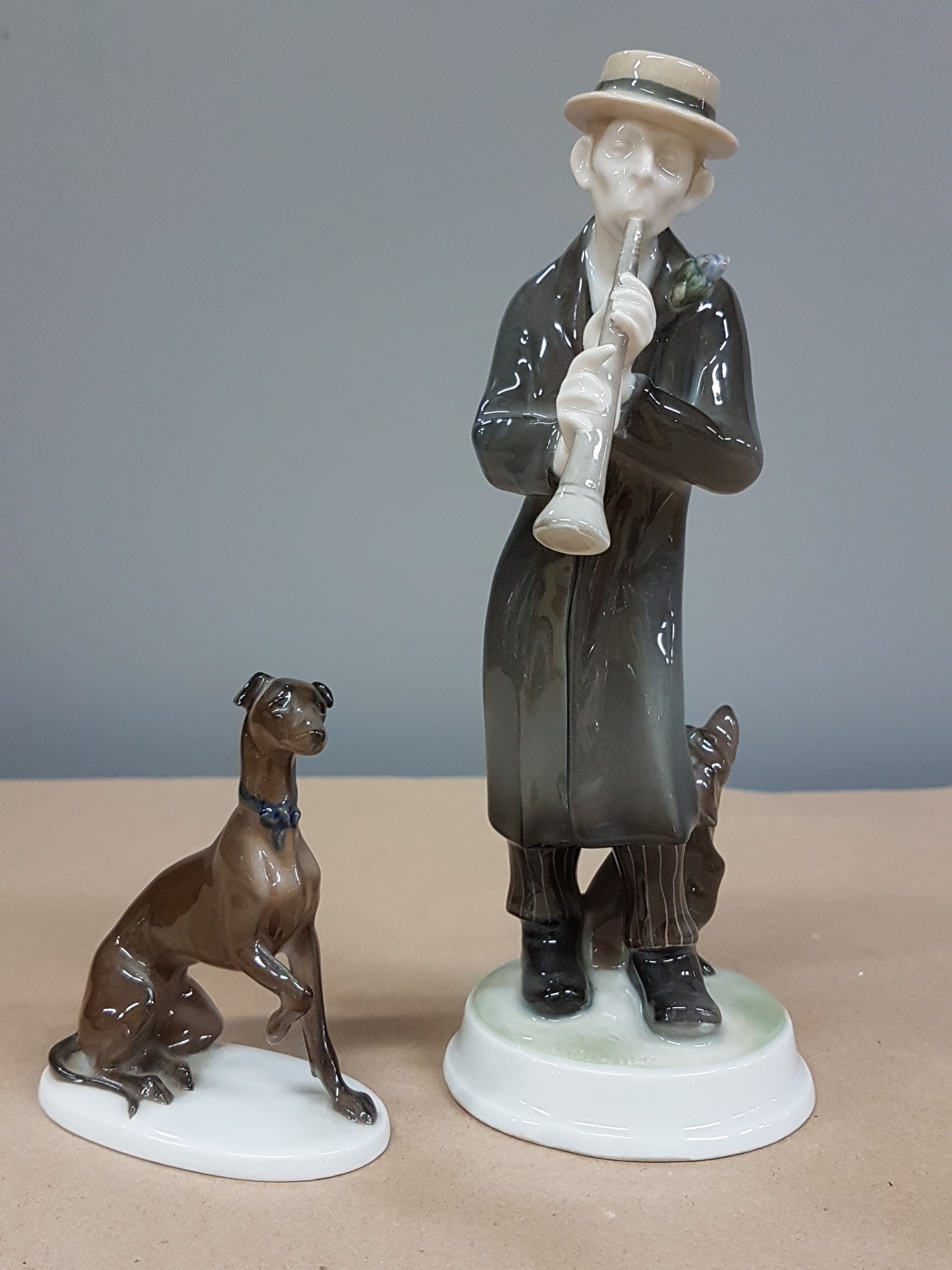 Detail a: Zwei Figuren Rosenthal, Kriegsmarke und, um 1920, Klarinettenspieler, 1914-18, am Hut min. best., H. ca. 20.5 cm, dazu Jagdhund, K 289, auf ovalem ...