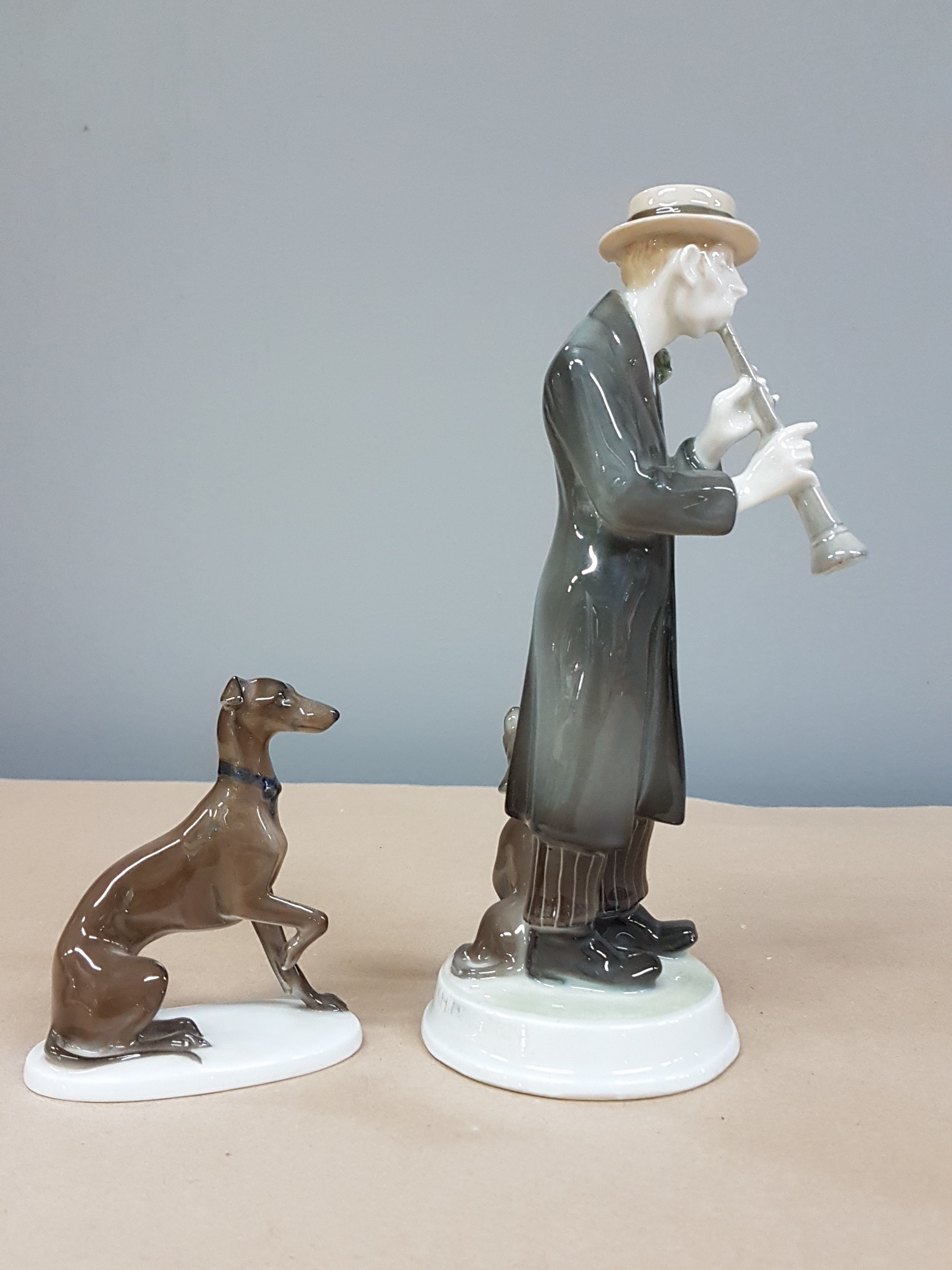 Detail b: Zwei Figuren Rosenthal, Kriegsmarke und, um 1920, Klarinettenspieler, 1914-18, am Hut min. best., H. ca. 20.5 cm, dazu Jagdhund, K 289, auf ovalem ...