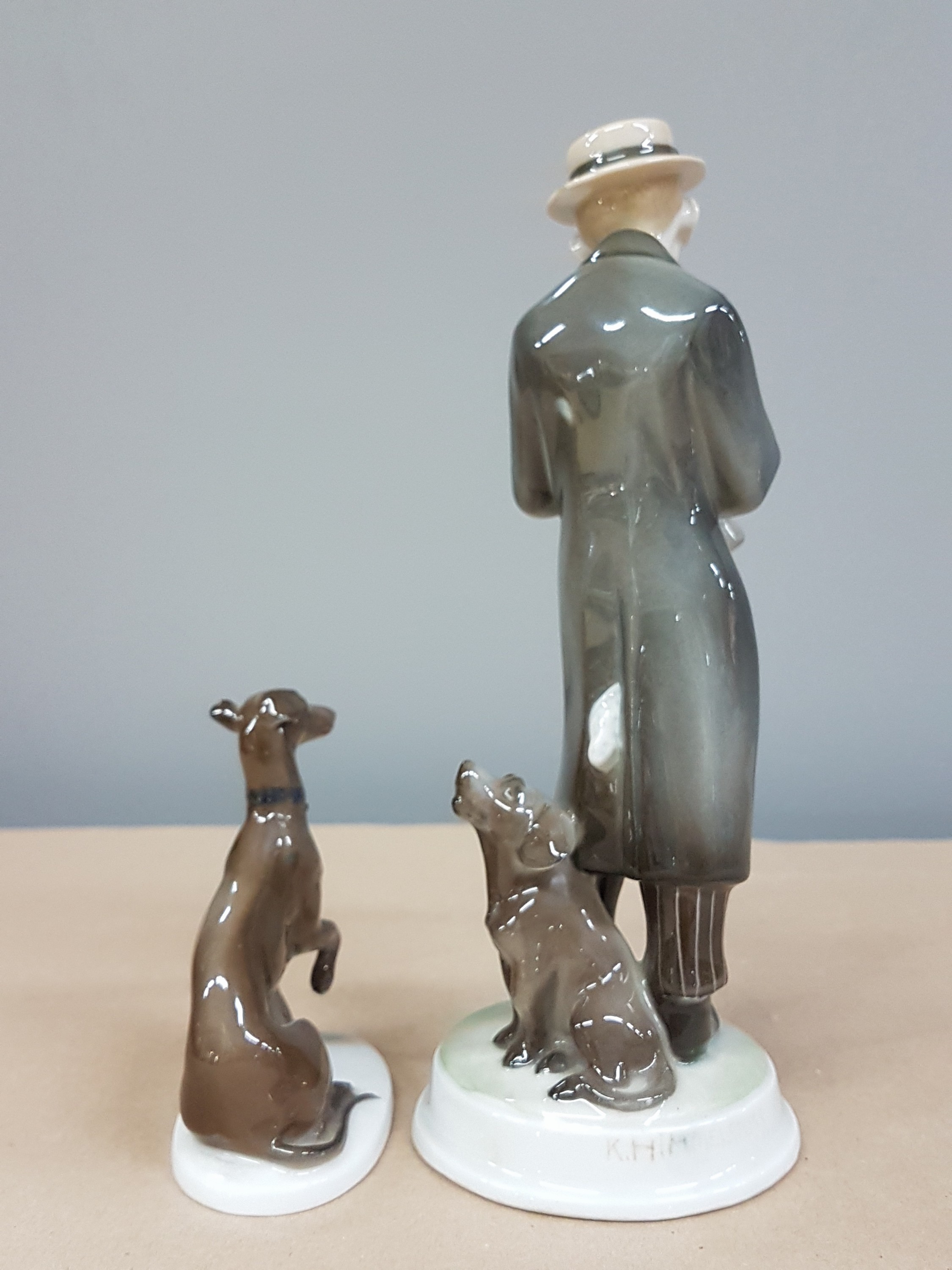 Detail c: Zwei Figuren Rosenthal, Kriegsmarke und, um 1920, Klarinettenspieler, 1914-18, am Hut min. best., H. ca. 20.5 cm, dazu Jagdhund, K 289, auf ovalem ...