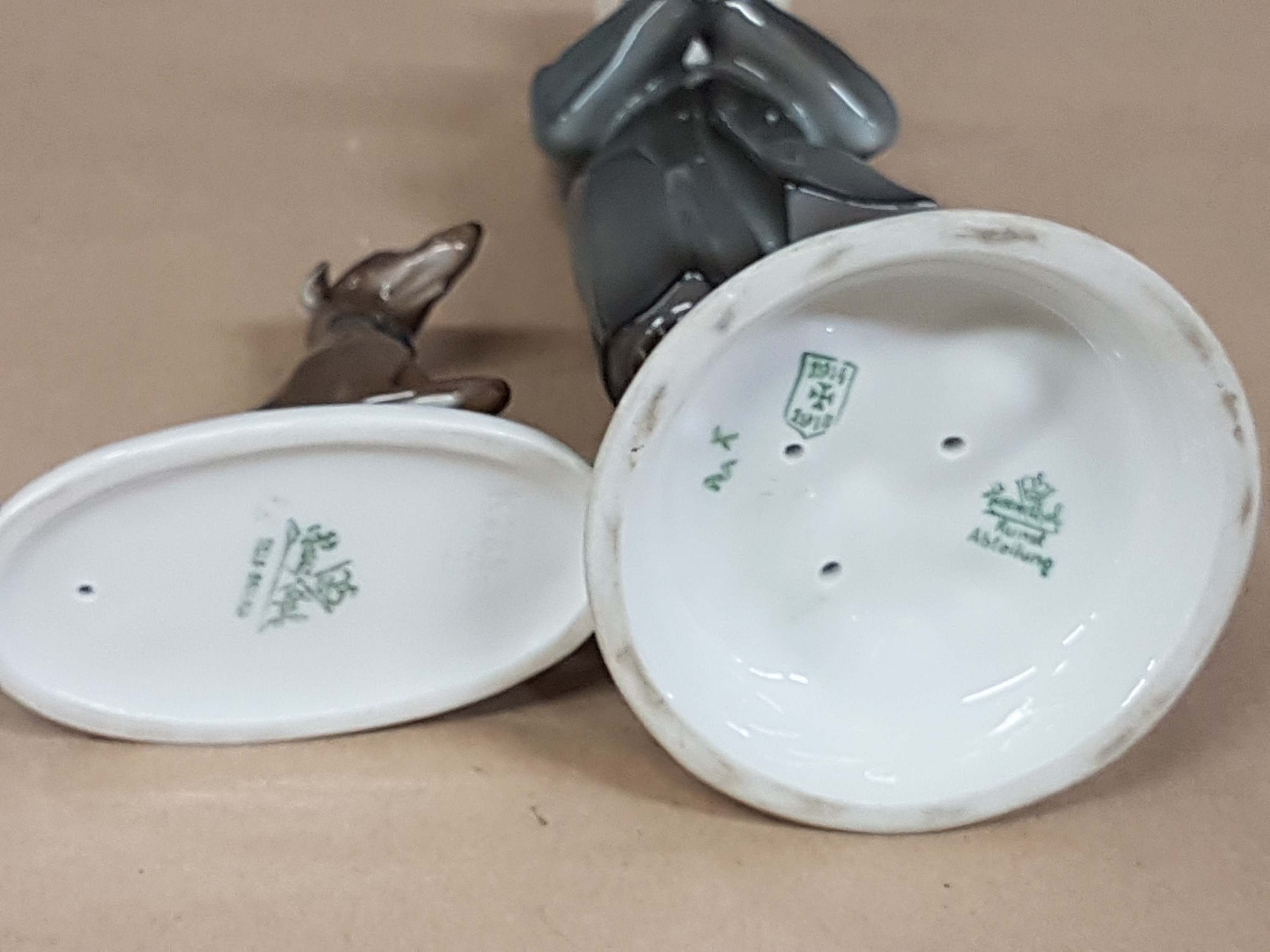 Detail i: Zwei Figuren Rosenthal, Kriegsmarke und, um 1920, Klarinettenspieler, 1914-18, am Hut min. best., H. ca. 20.5 cm, dazu Jagdhund, K 289, auf ovalem ...