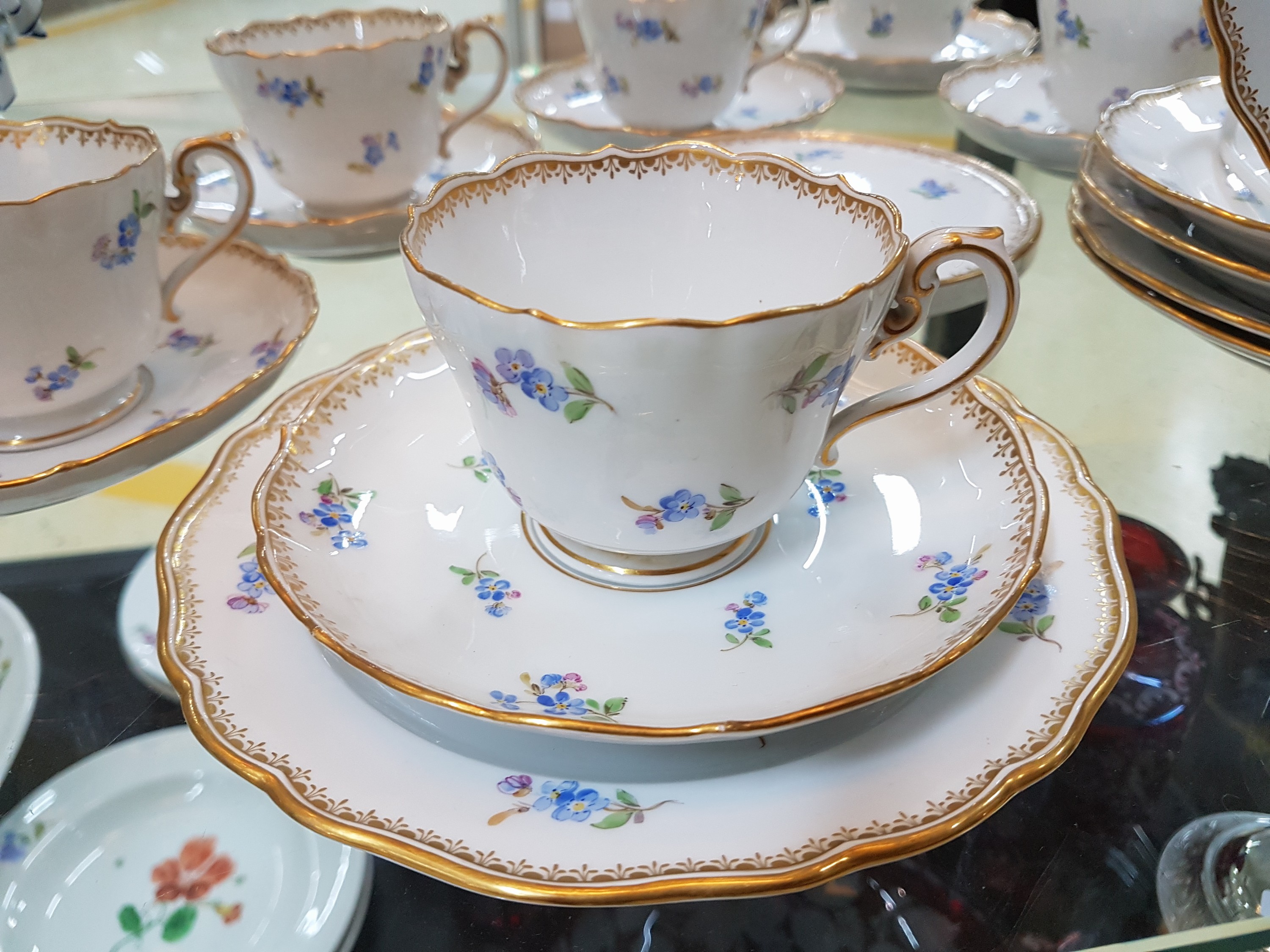 Detail b: 6 Tassen mit Untertassen, 6 Gebäckteller, Meissen, um 1900, 1. Wahl, Porzellan, but bemalt mit gestreuten Vergissmeinnicht, Goldkante, dazu ...