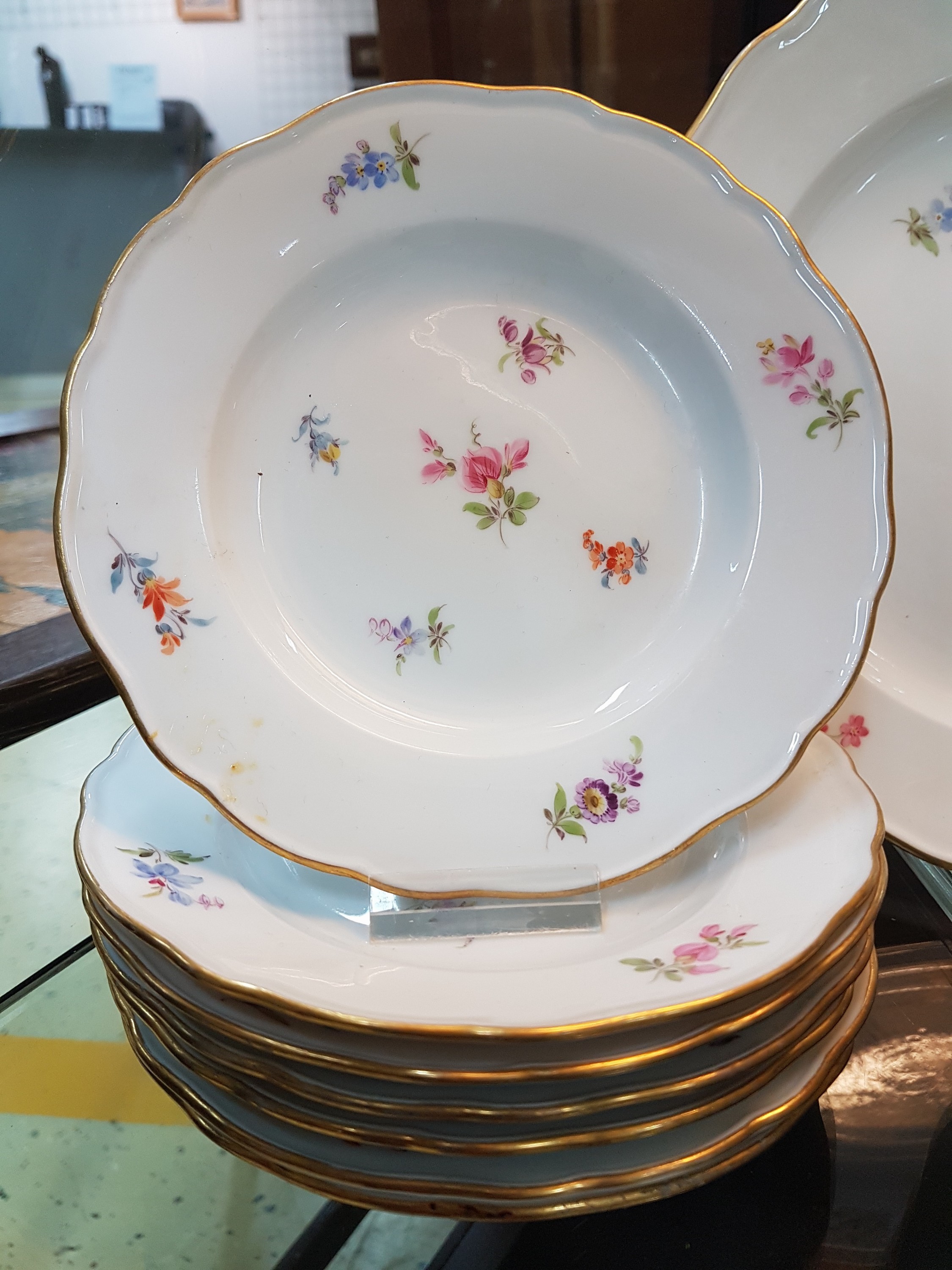 Detail b: 28 Teile Porzellan, Meissen, um 1900, 1. und 2. Wahl, Dekor gestreute Blumen, Goldränder, leicht berieben, 9 flache Teller 24.5cm, 6 tiefe Teller ...