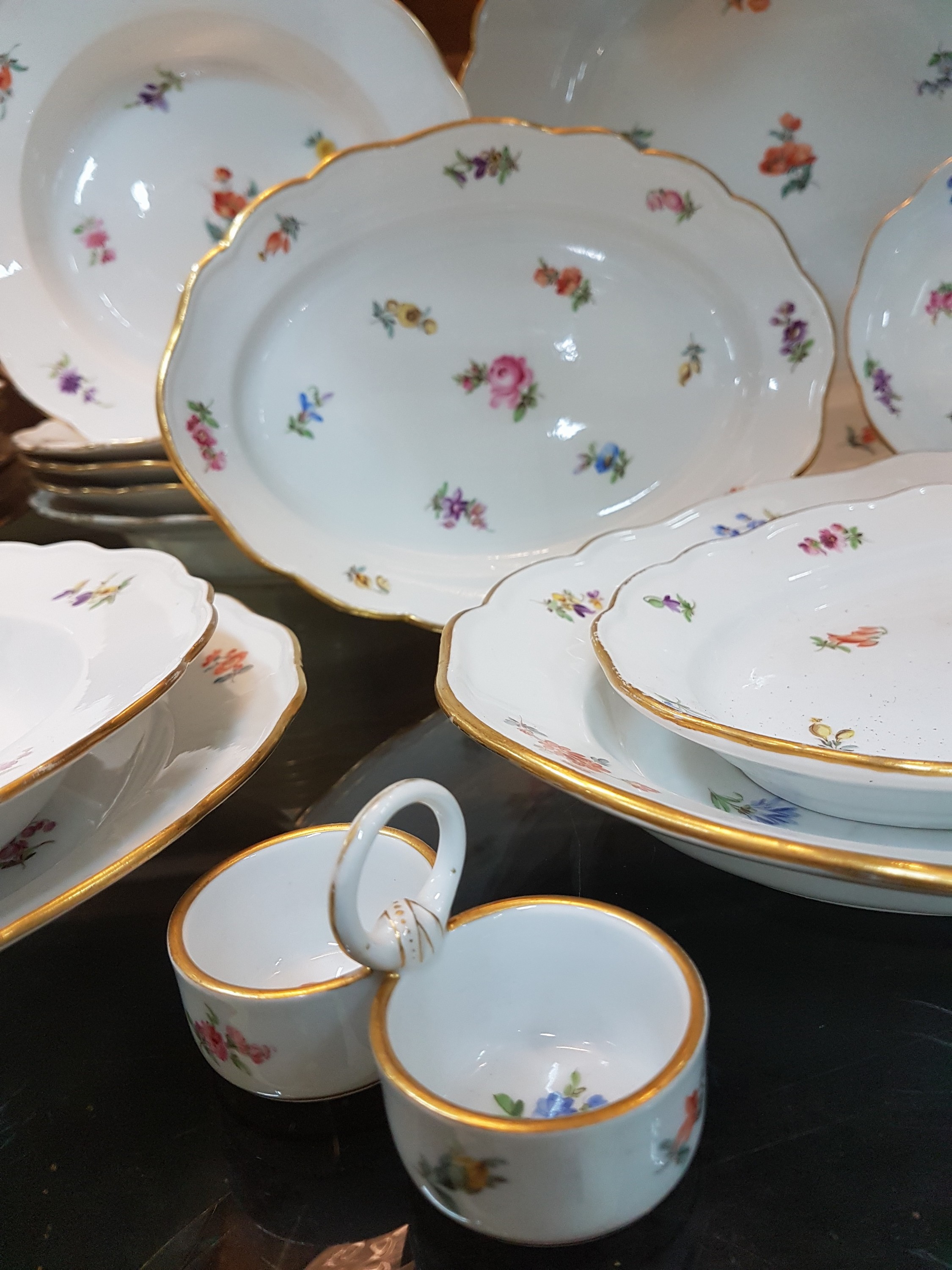 Detail c: 28 Teile Porzellan, Meissen, um 1900, 1. und 2. Wahl, Dekor gestreute Blumen, Goldränder, leicht berieben, 9 flache Teller 24.5cm, 6 tiefe Teller ...