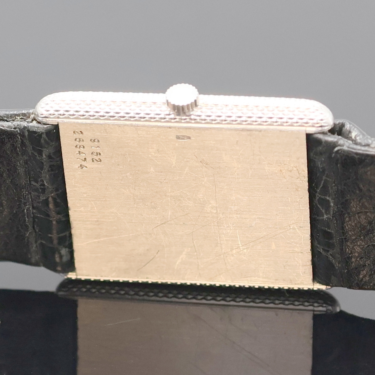 Detail e: PIAGET Protocole Armbanduhr in WG 750/000 Referenz 9152, Schweiz 1960, Handaufzug, Boden aufgedr., Lünette guill./strukt., orig. Lederband m. ...
