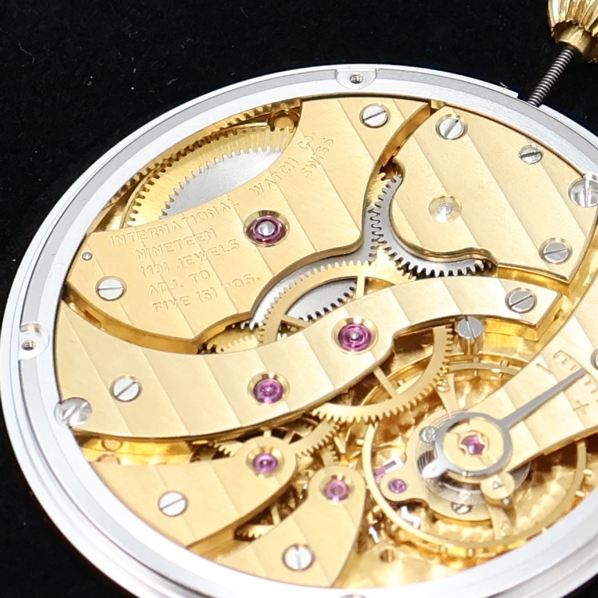 Detail a: IWC vergoldetes Taschenuhrwerk Kaliber 9520,Schweiz um 1970, verg. Werk m. Streifenschl., 19 St., 5 Adj., Emailfarb. Zifferbl. m. röm. Zahlen, ...