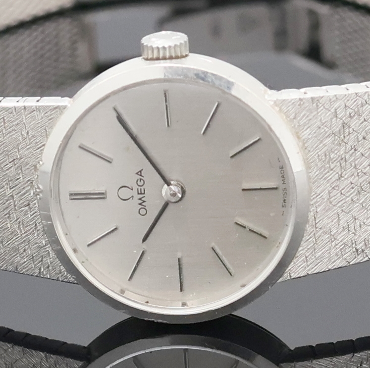 Detail a: OMEGA Damenarmbanduhr in WG 585/000 Referenz 7280, Schweiz um 1973, Handaufzug, Boden aufgedr., orig. Milanaiseband, silb. Zifferbl. m. aufgel. Ind. ...