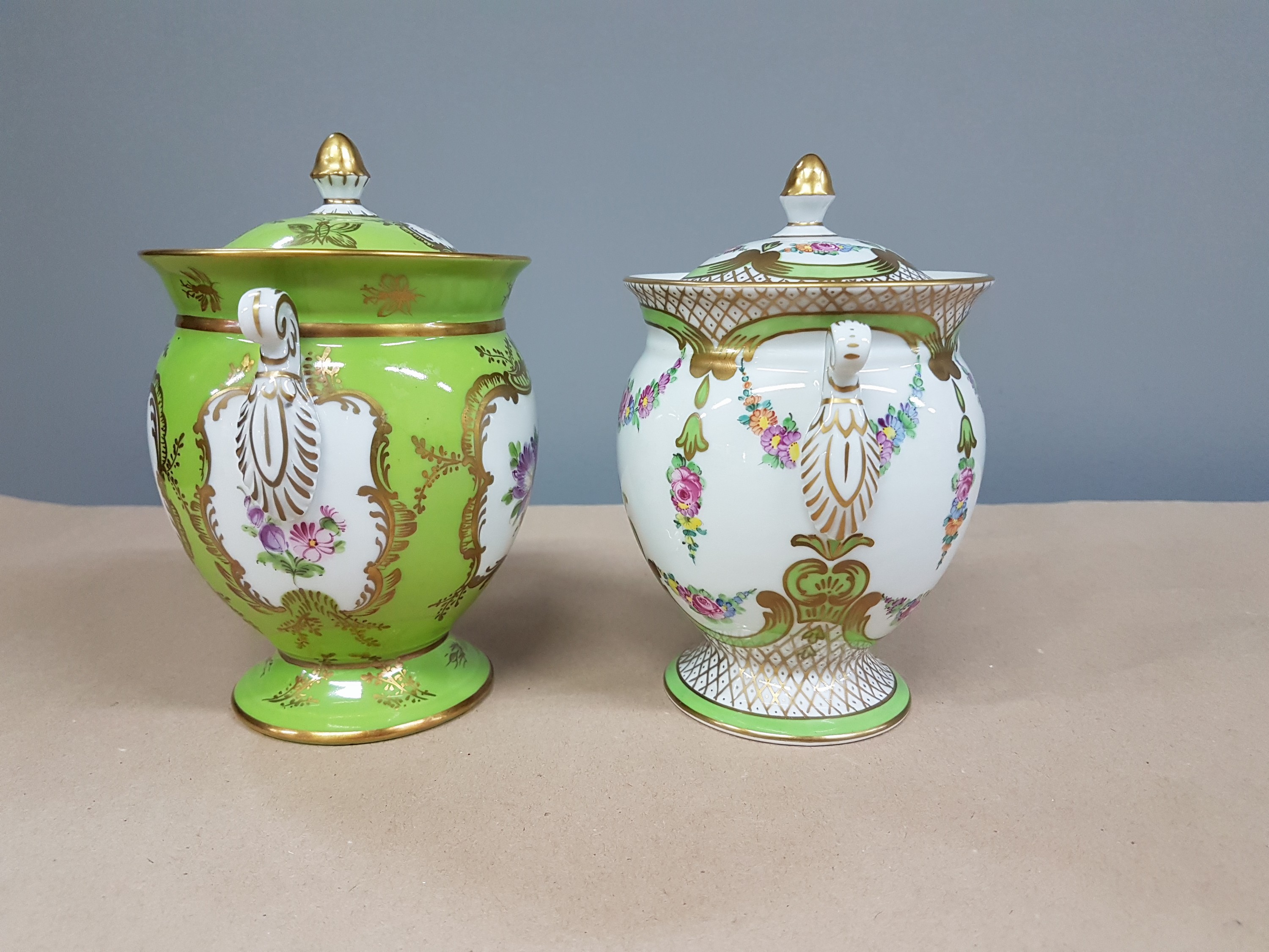 Detail d: 2 Deckelvasen, Dresden, um 1900, Porzellan, partiell grüngrundig, reiche Goldstaffage, Blumendekor, H. ca. 14.5cm