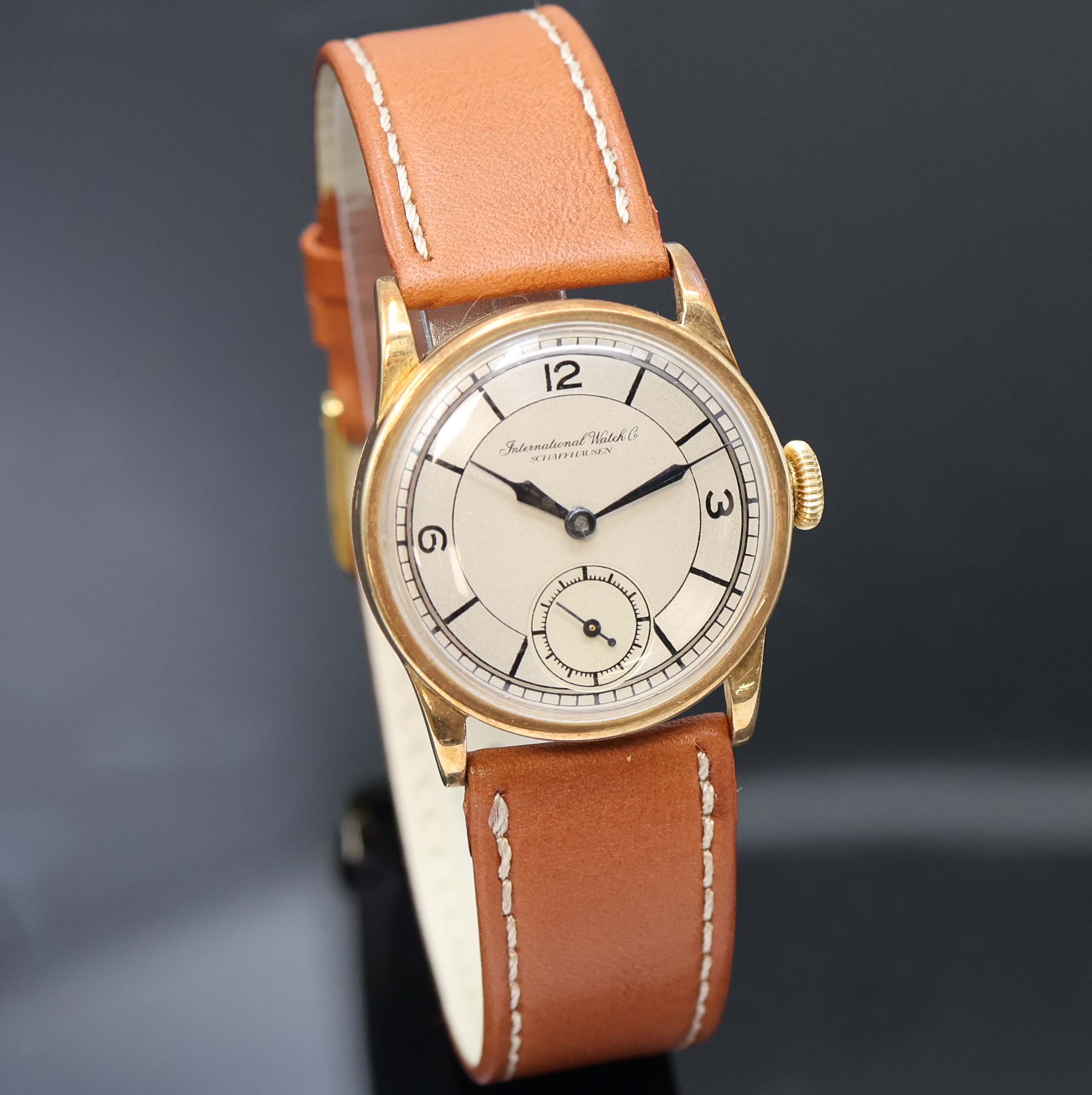 Detail b: IWC Herrenarmbanduhr in GG 585/000, Schweiz um 1934, Handaufzug, Boden u. Glasrand aufgedr., silb. Duoton-Zifferbl. rest., gebl. Stahlz., ...