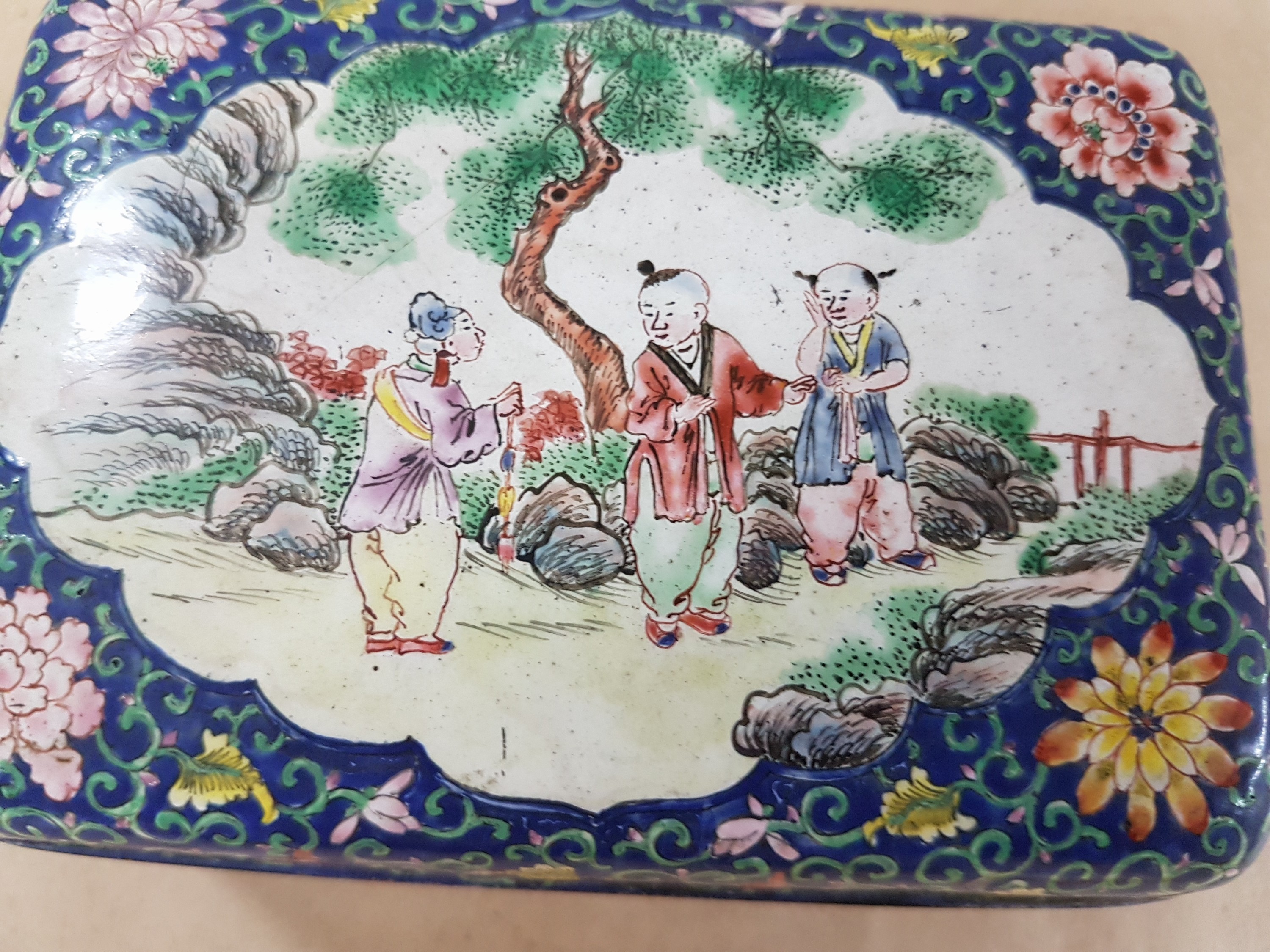Detail f: Deckeldose, China, 20. Jh., Emailarbeit, 3 figürliche Szenen in Landschaft bemalt, zwei Kartuschen mit Blumenmalerei, ca. 6 x 12 x 9 cm