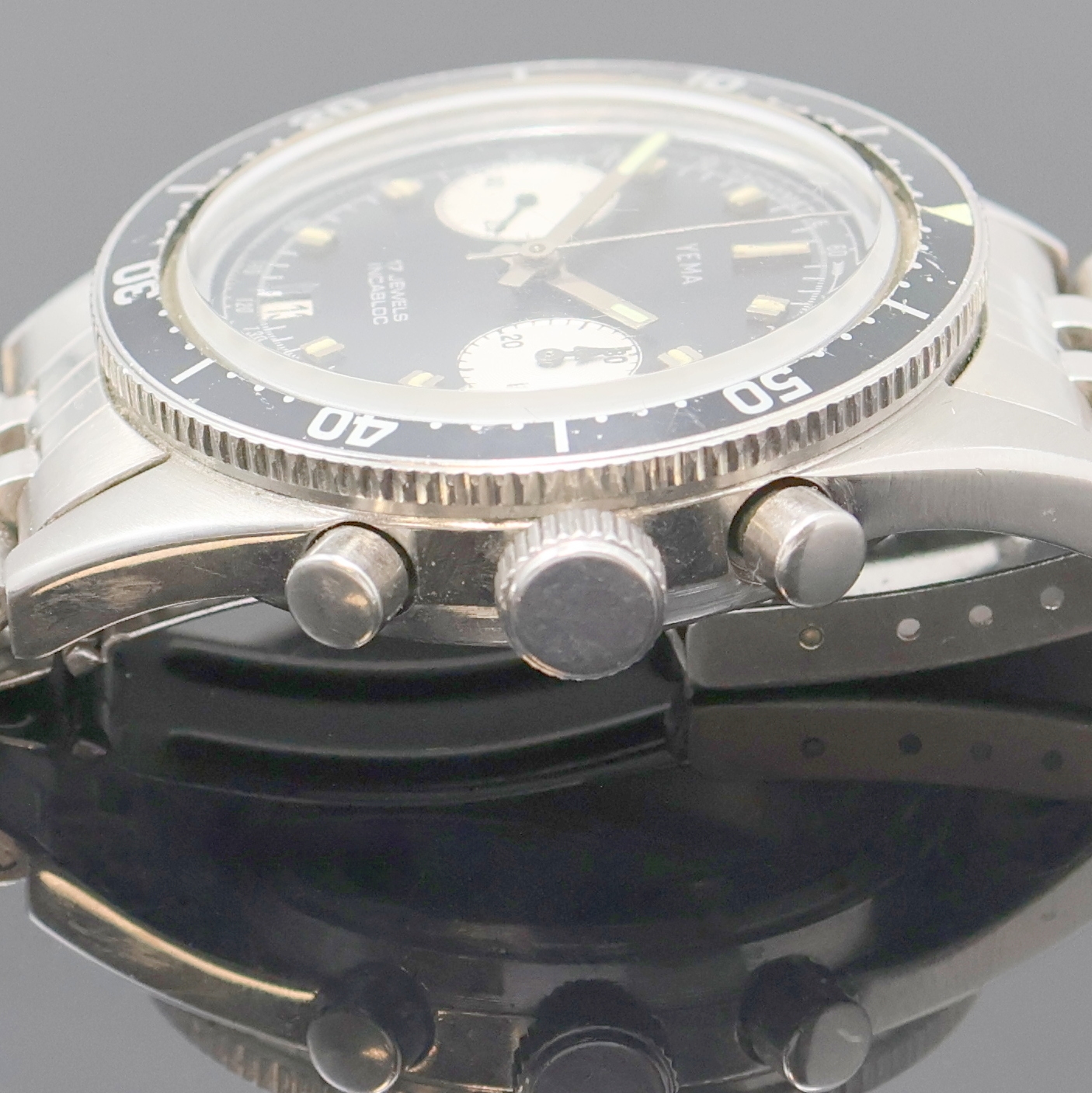 Detail d: YEMA Armbandchronograph in Stahl, Schweiz um 1970, Handaufzug, Boden verschr., neutr. Gliederband m. Faltschl., Lünette m. 60er Teil. beids. drehb., ...