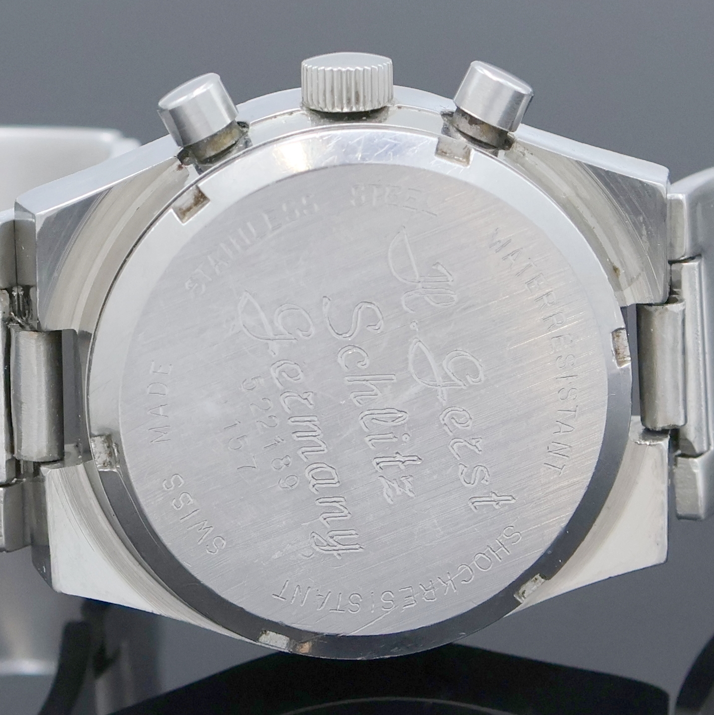 Detail e: DUGENA Armbandchronograph Referenz 157, Schweiz um 1970, Handaufzug, Edelstahlgeh. inkl. Stahlband, Boden m. Widmung verschr., Fume-Zifferbl. m. ...
