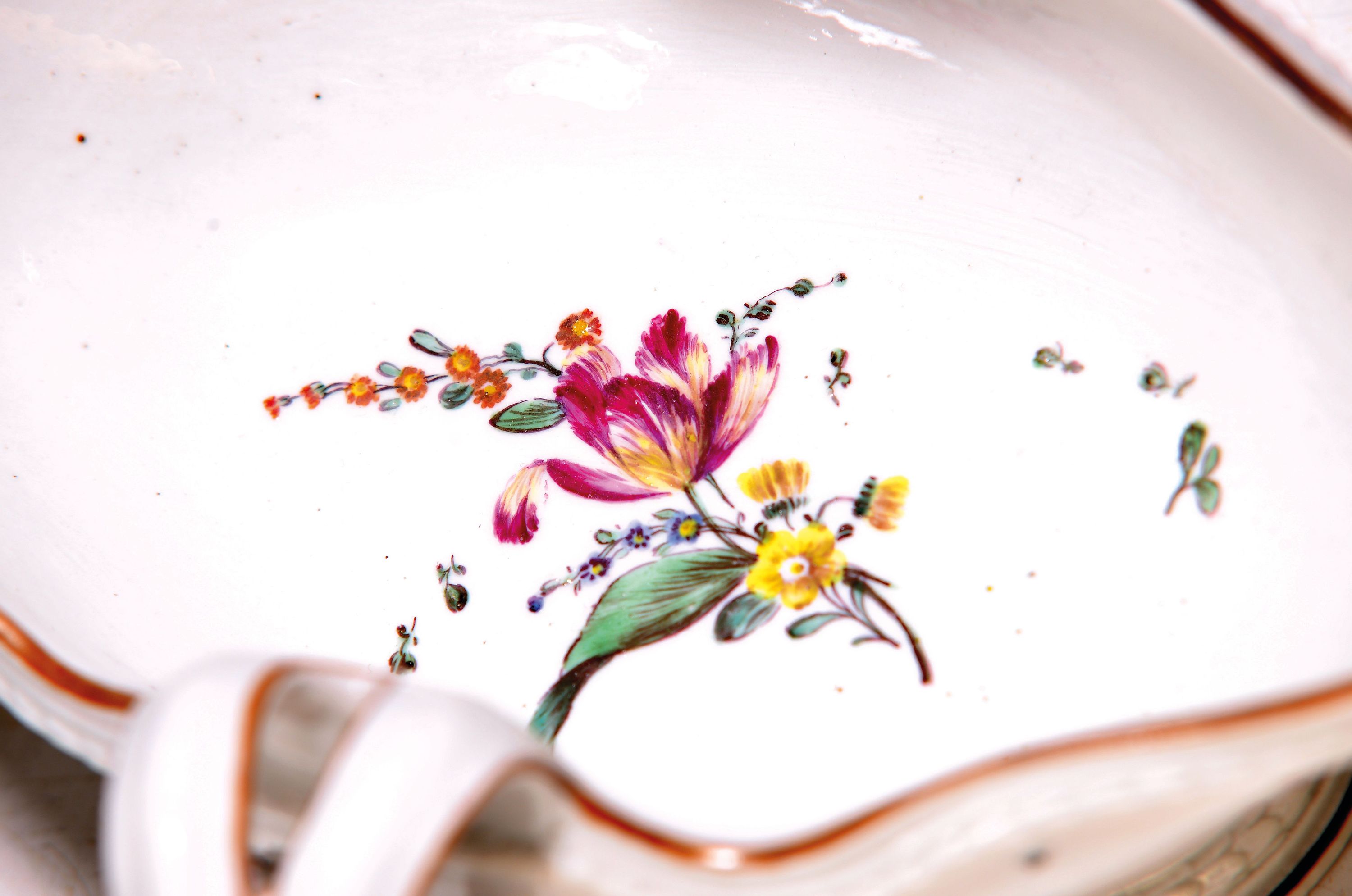 Detail a: Sauciere, Frankenthal, um 1775, gekreuzte Griffe, umlaufendes Lorbeerband um Fuß und Rand, ockerfarbener Rand, innen mit Blumengebinde und gestreute ...