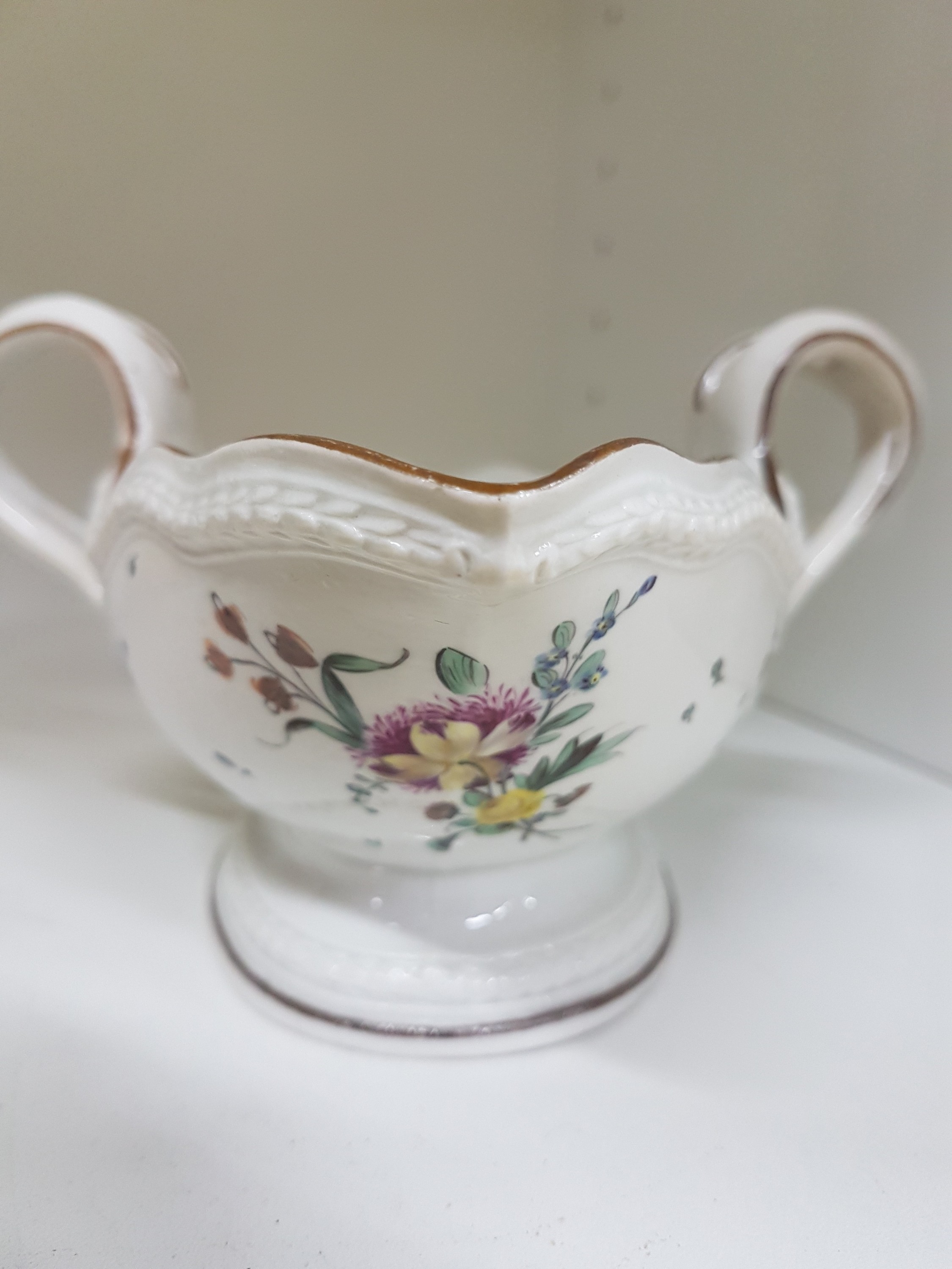 Detail f: Sauciere, Frankenthal, um 1775, gekreuzte Griffe, umlaufendes Lorbeerband um Fuß und Rand, ockerfarbener Rand, innen mit Blumengebinde und gestreute ...