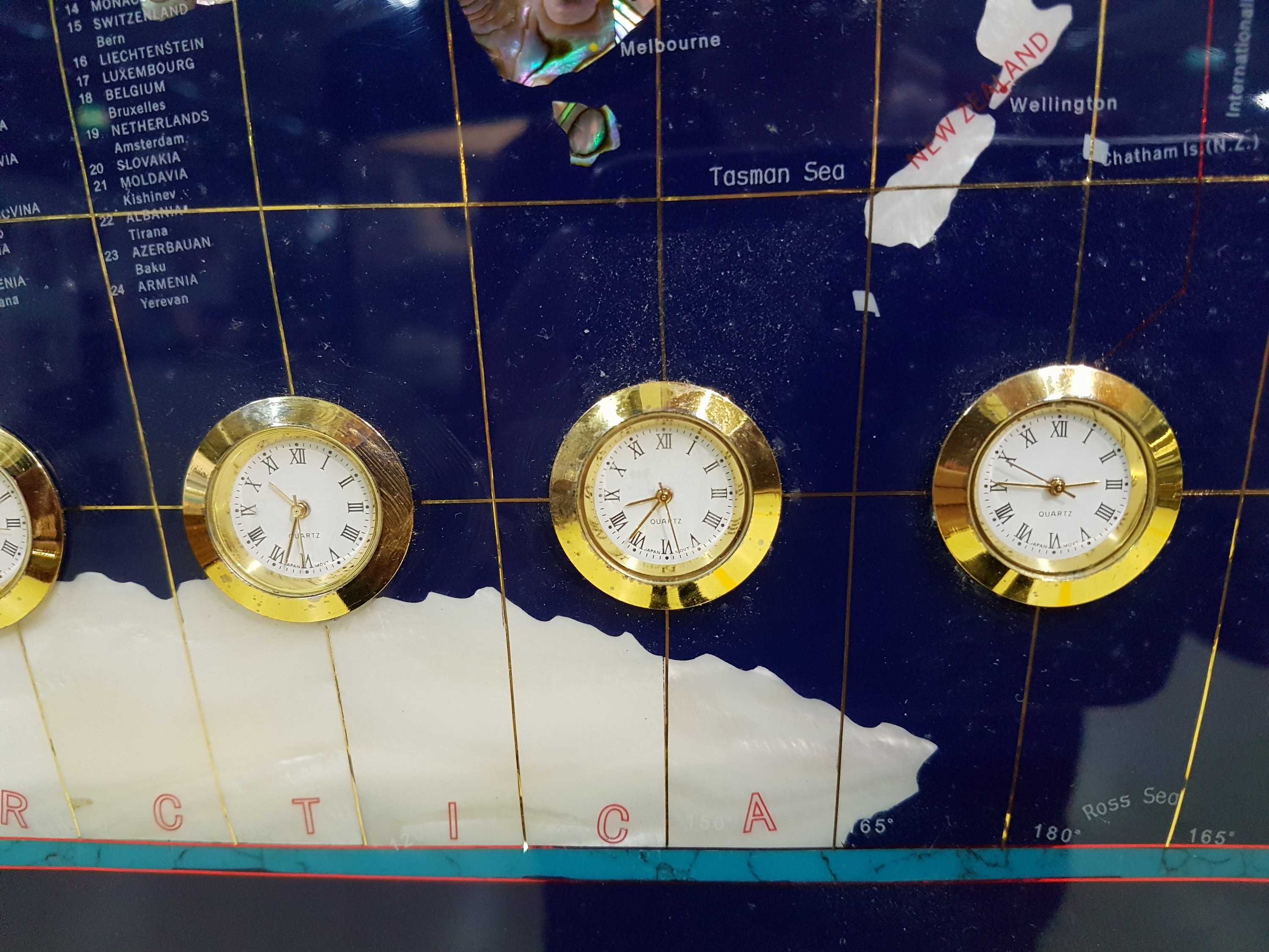 Detail e: Weltzeituhr aus Halbedelsteinen, Weltkarte aus blauem Lack mit eingelegten Halbedelsteinen die Länder repräsentierend, 9 kleine Quartzuhren ...