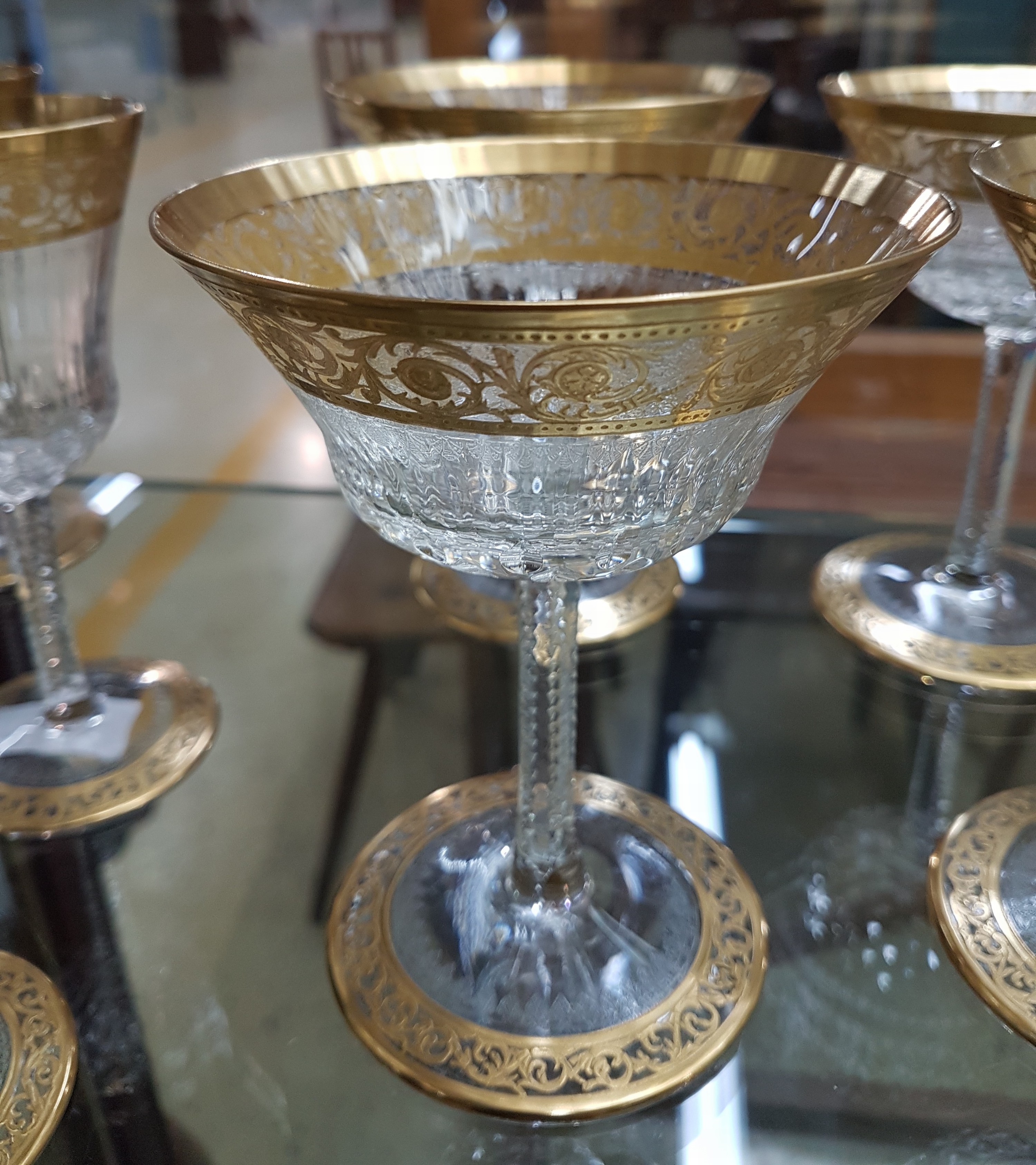 Detail b: 7 Champagnerschalen, Saint Louis, Dekor Thistle, farbloses Kristallglas, breit geätzte Goldbordüre, H. 13 cm
