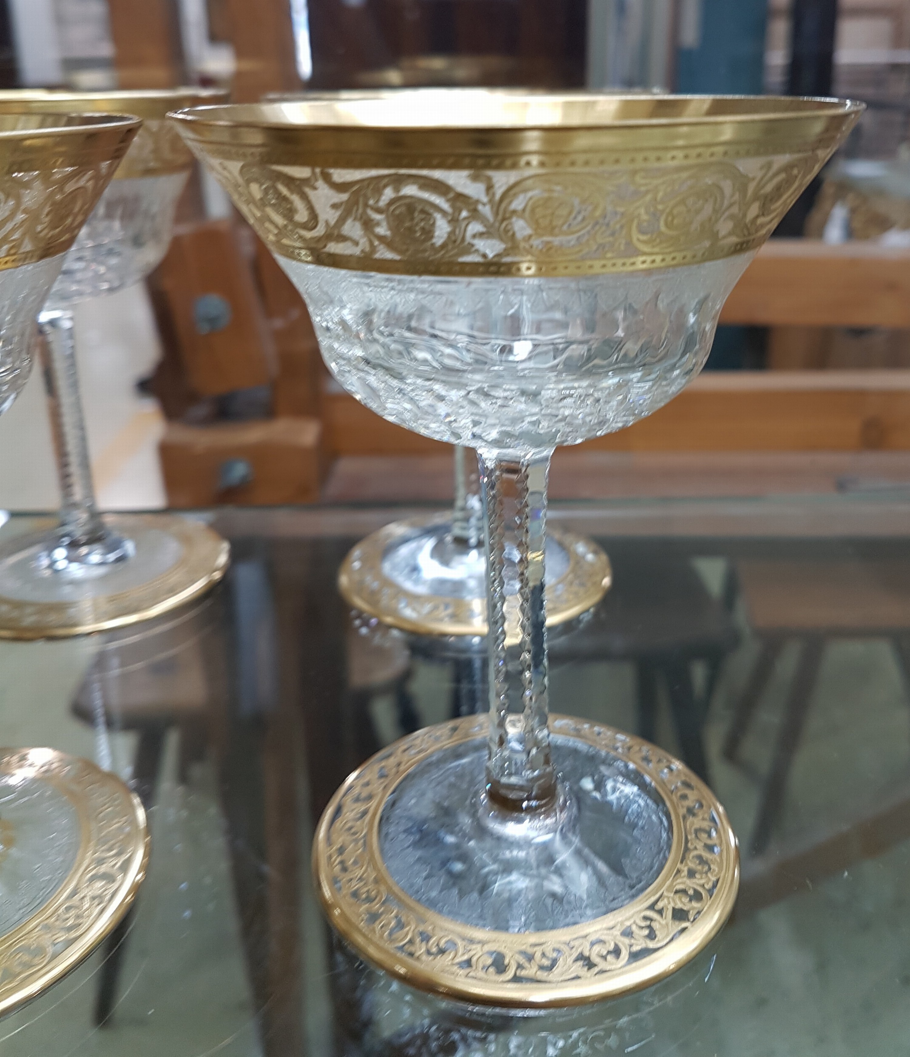 Detail c: 7 Champagnerschalen, Saint Louis, Dekor Thistle, farbloses Kristallglas, breit geätzte Goldbordüre, H. 13 cm