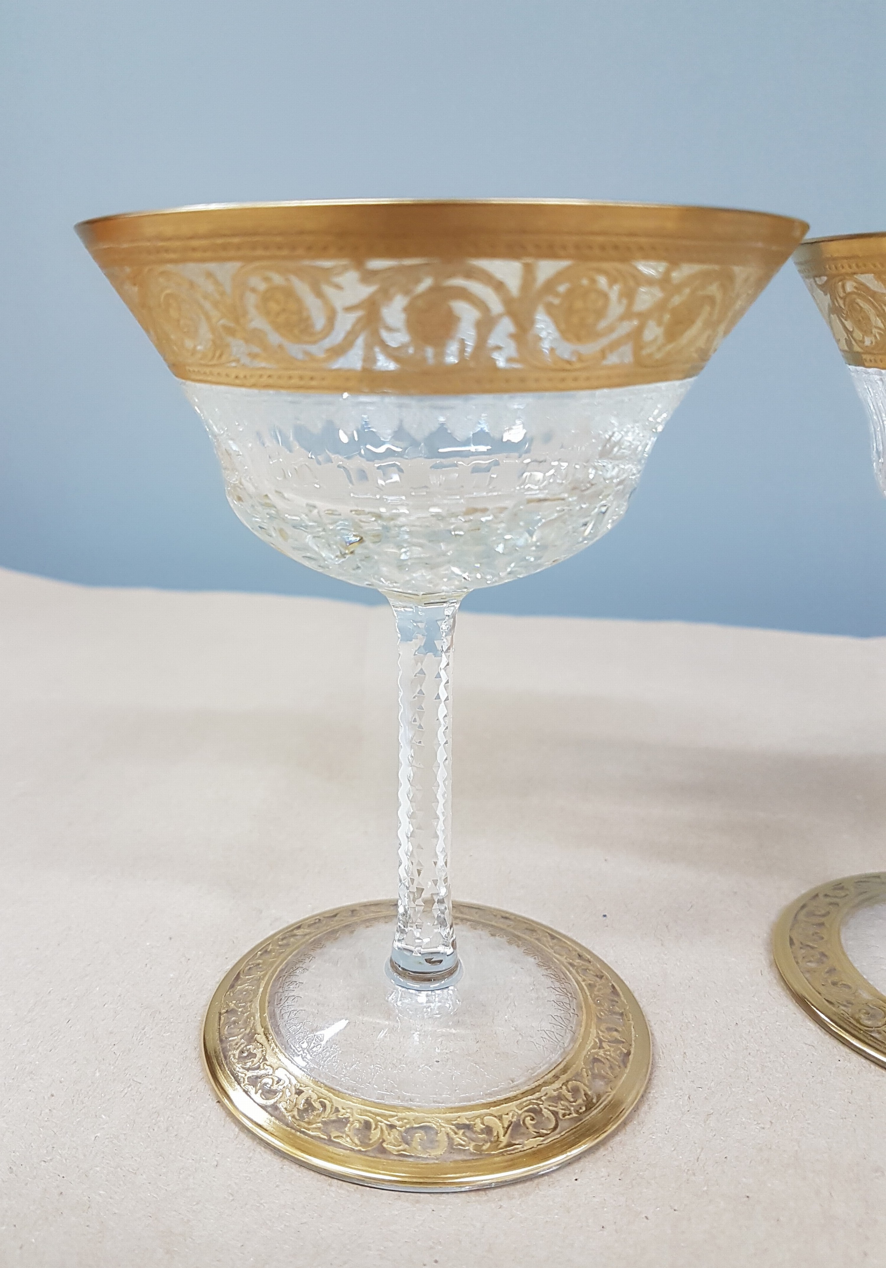 Detail e: 7 Champagnerschalen, Saint Louis, Dekor Thistle, farbloses Kristallglas, breit geätzte Goldbordüre, H. 13 cm