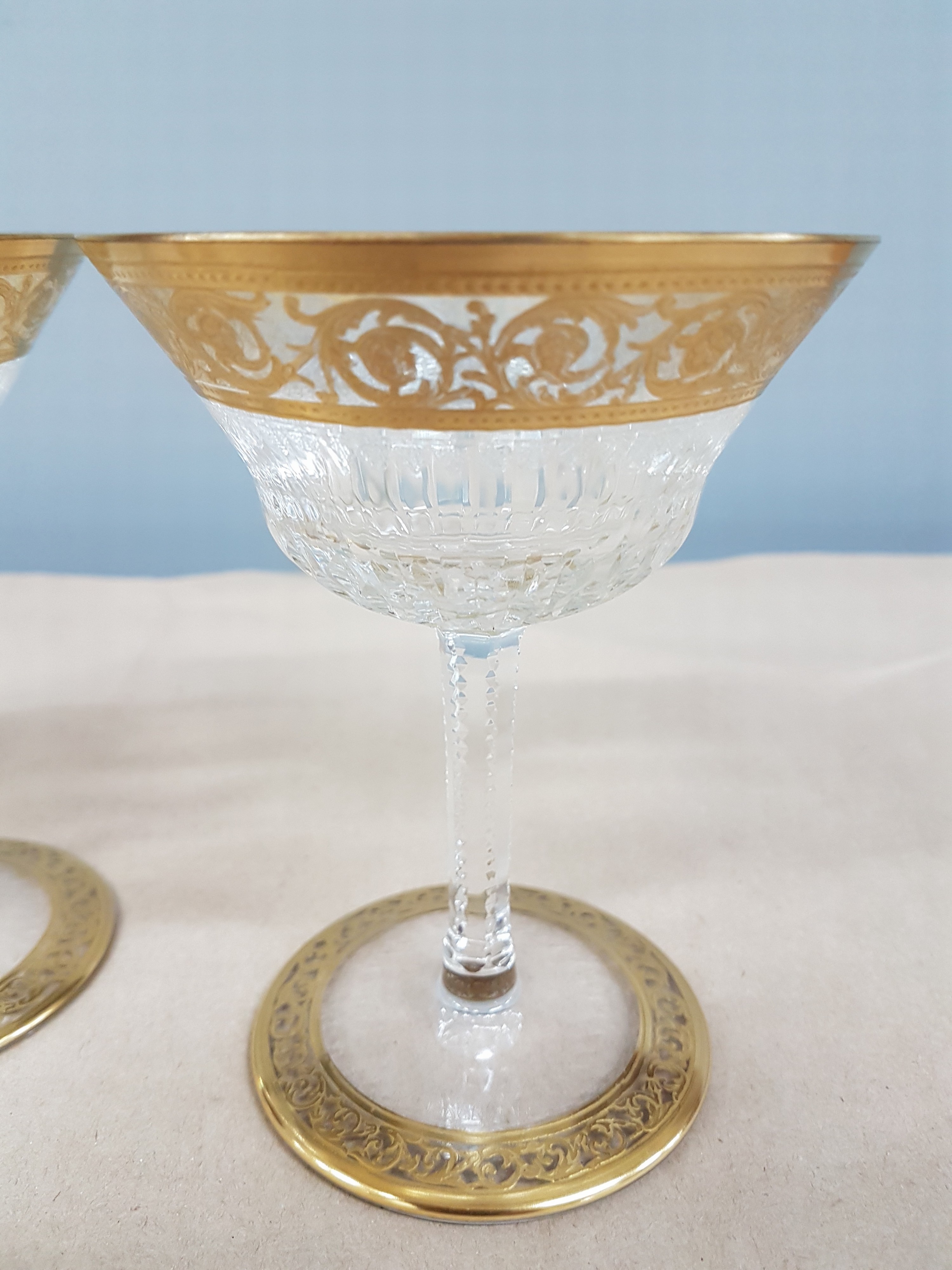 Detail g: 7 Champagnerschalen, Saint Louis, Dekor Thistle, farbloses Kristallglas, breit geätzte Goldbordüre, H. 13 cm