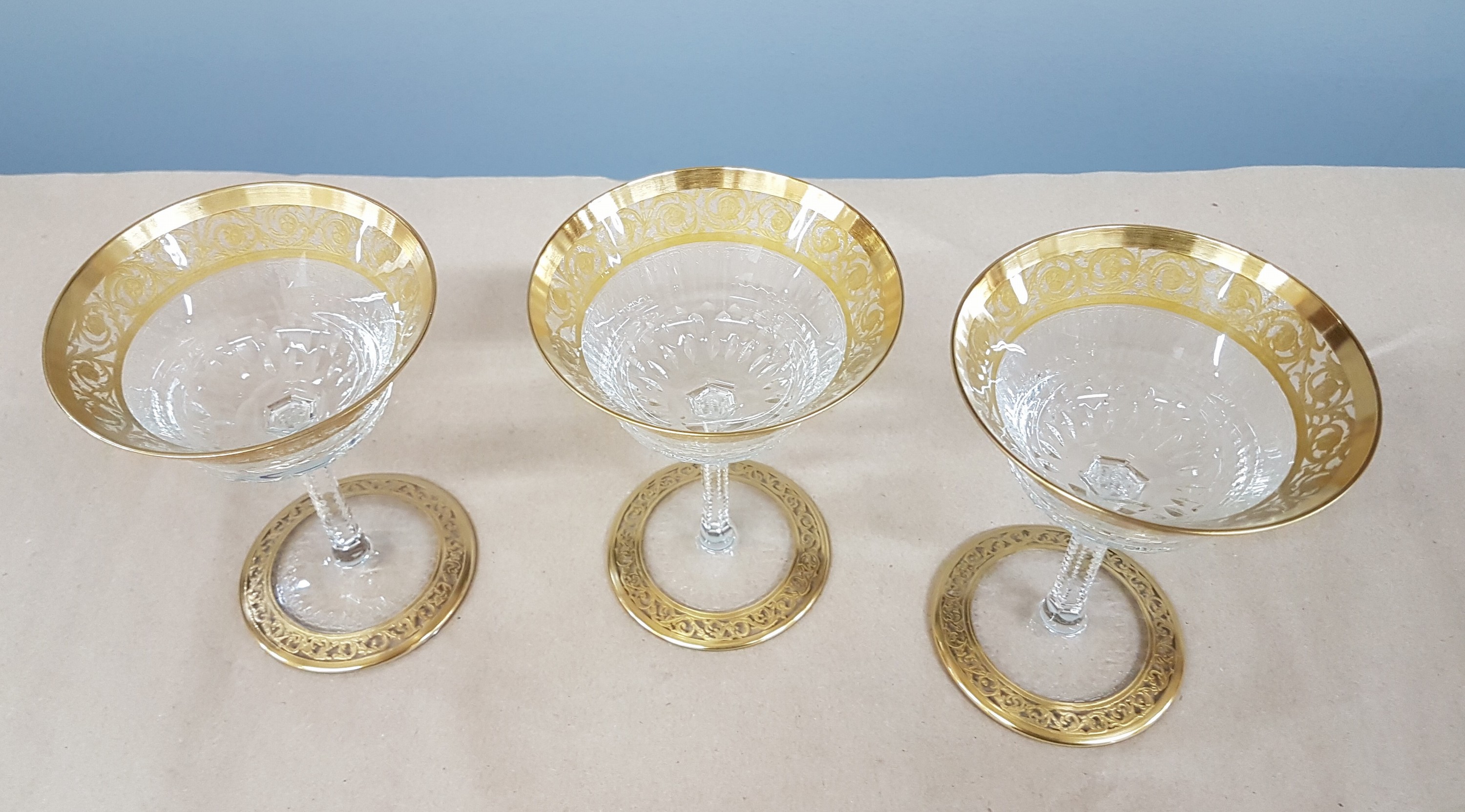 Detail k: 7 Champagnerschalen, Saint Louis, Dekor Thistle, farbloses Kristallglas, breit geätzte Goldbordüre, H. 13 cm