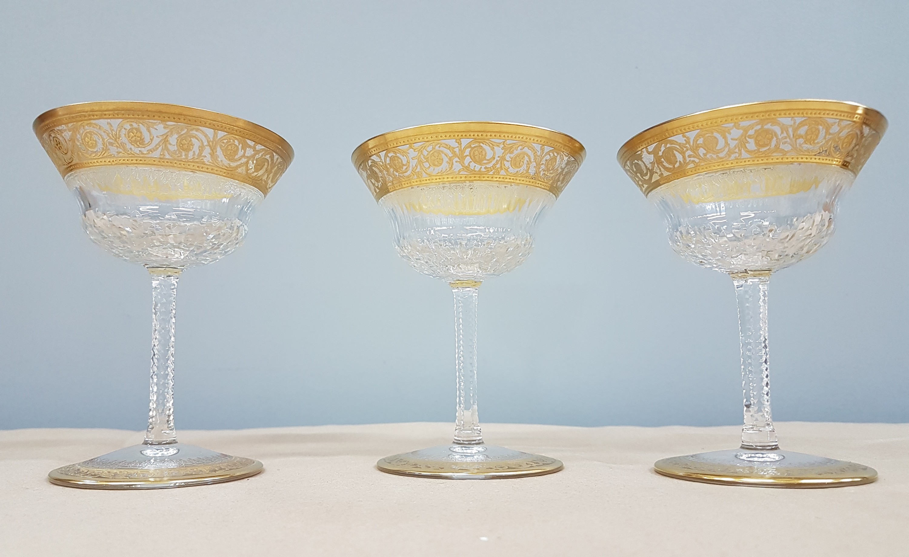 Detail l: 7 Champagnerschalen, Saint Louis, Dekor Thistle, farbloses Kristallglas, breit geätzte Goldbordüre, H. 13 cm