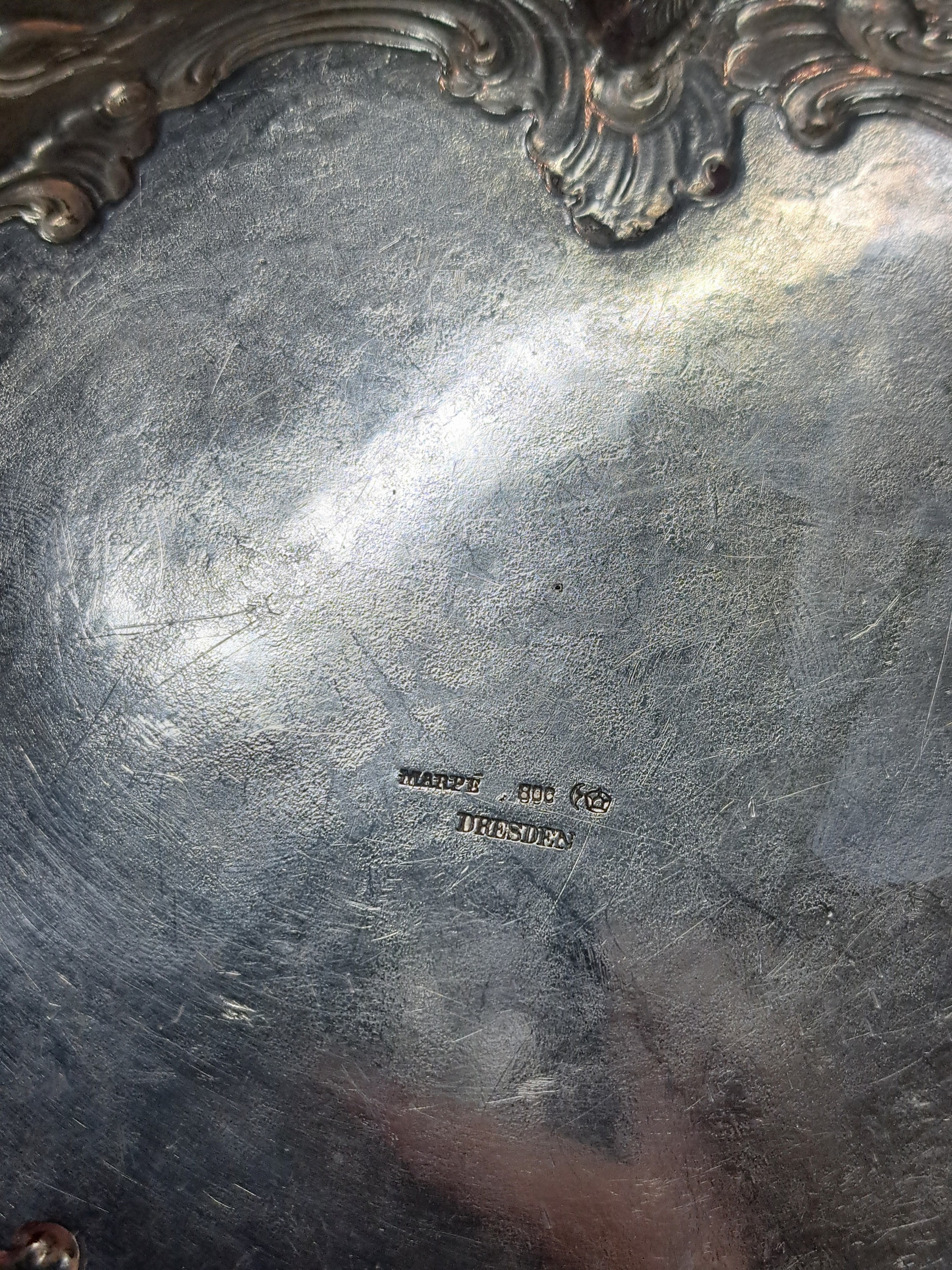 Detail a: Runde Schale, Marpé, um 1890, mit Adelswappen gekrönter Stern mit Gefäß (wohl Nidda) Rocaillen und Blumendekor, ca. 380g, auf drei Füssen ...
