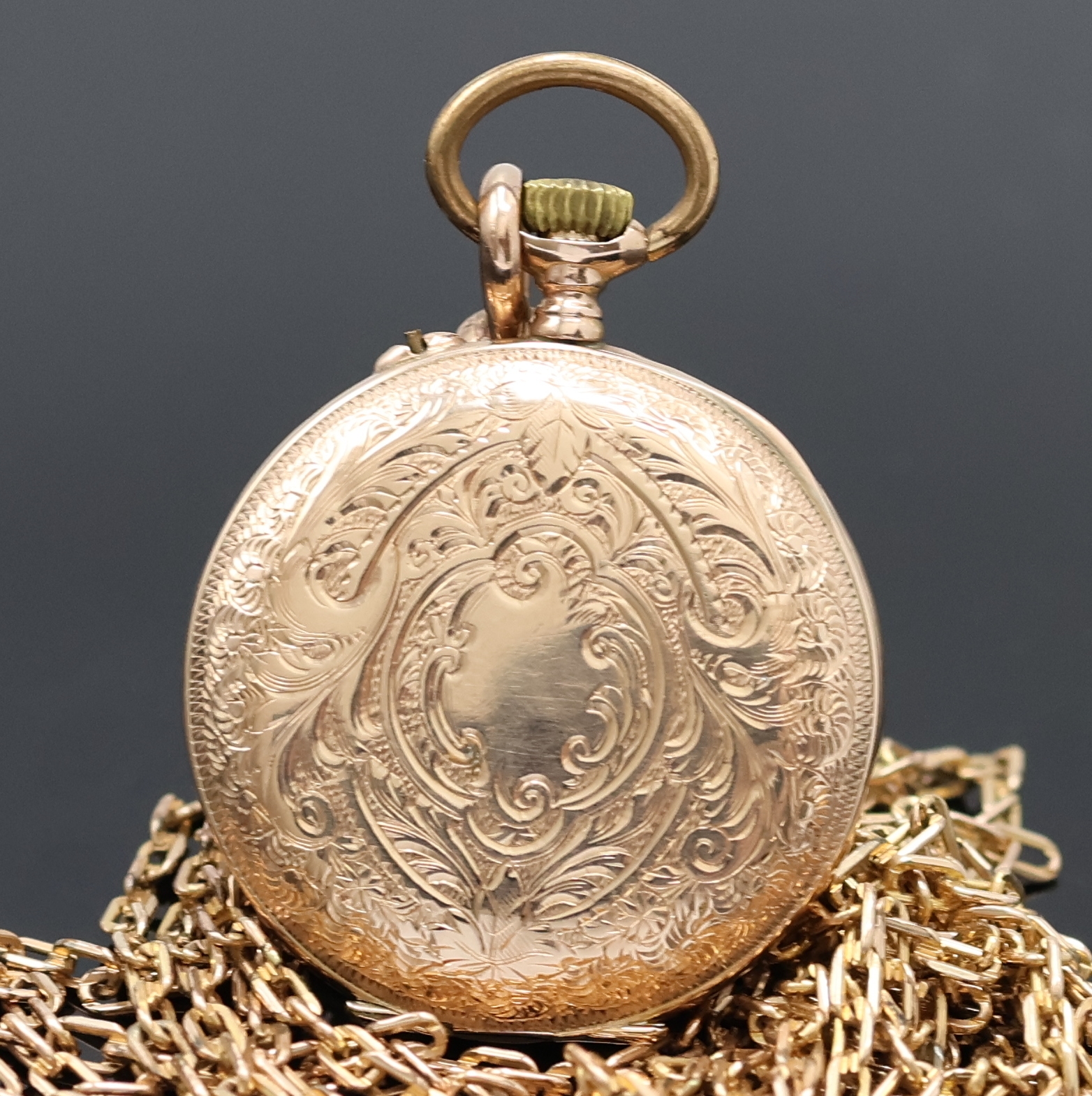 Detail a: Offene Damentaschenuhr in RoseG 585/000 mit vergoldeter Kette, Schweiz um 1900, grav. Geh. dell., Metallcuvette, Emailzifferbl. m. röm. Zahlen, ...
