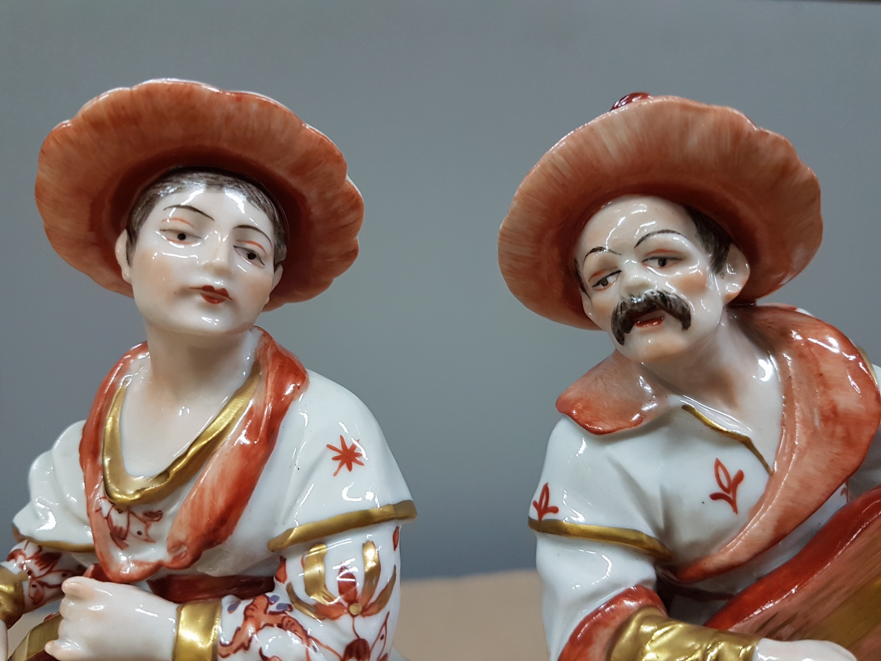 Detail g: Malabar und Malabarin, Volkstedt, 20. Jh., Porzellan, reich bemalt vorwiegend in Rot, 1 Daumen fehlt, Goldstaffage, H. ca. 20cm