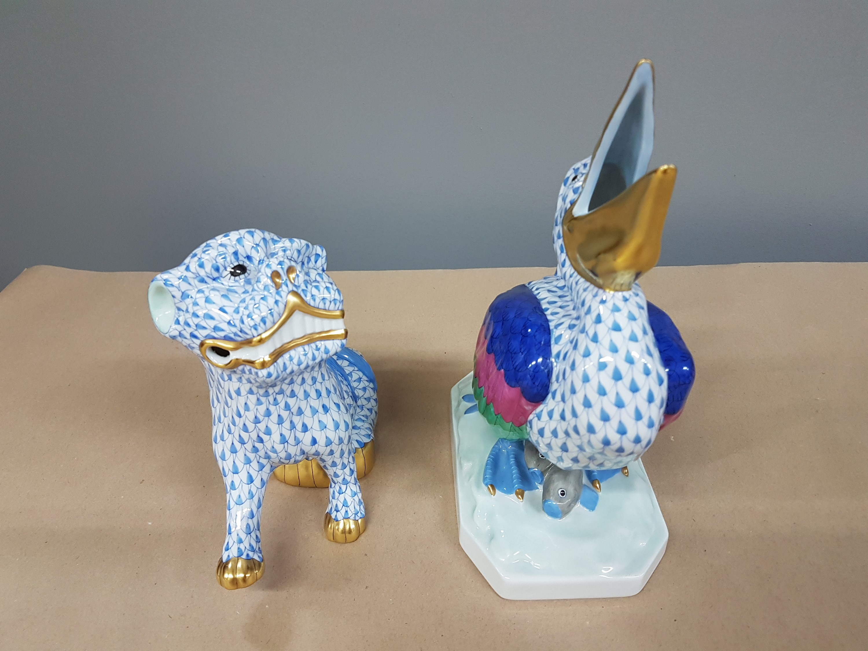 Detail d: 2 Porzellanfiguren, Herend Ungarn, 20. Jh., bunt bemalt mit blauem Fischnetzmuster und Goldstaffage, Fo-Hund H. ca. 15cm, Pelikan H. ca. 21cm