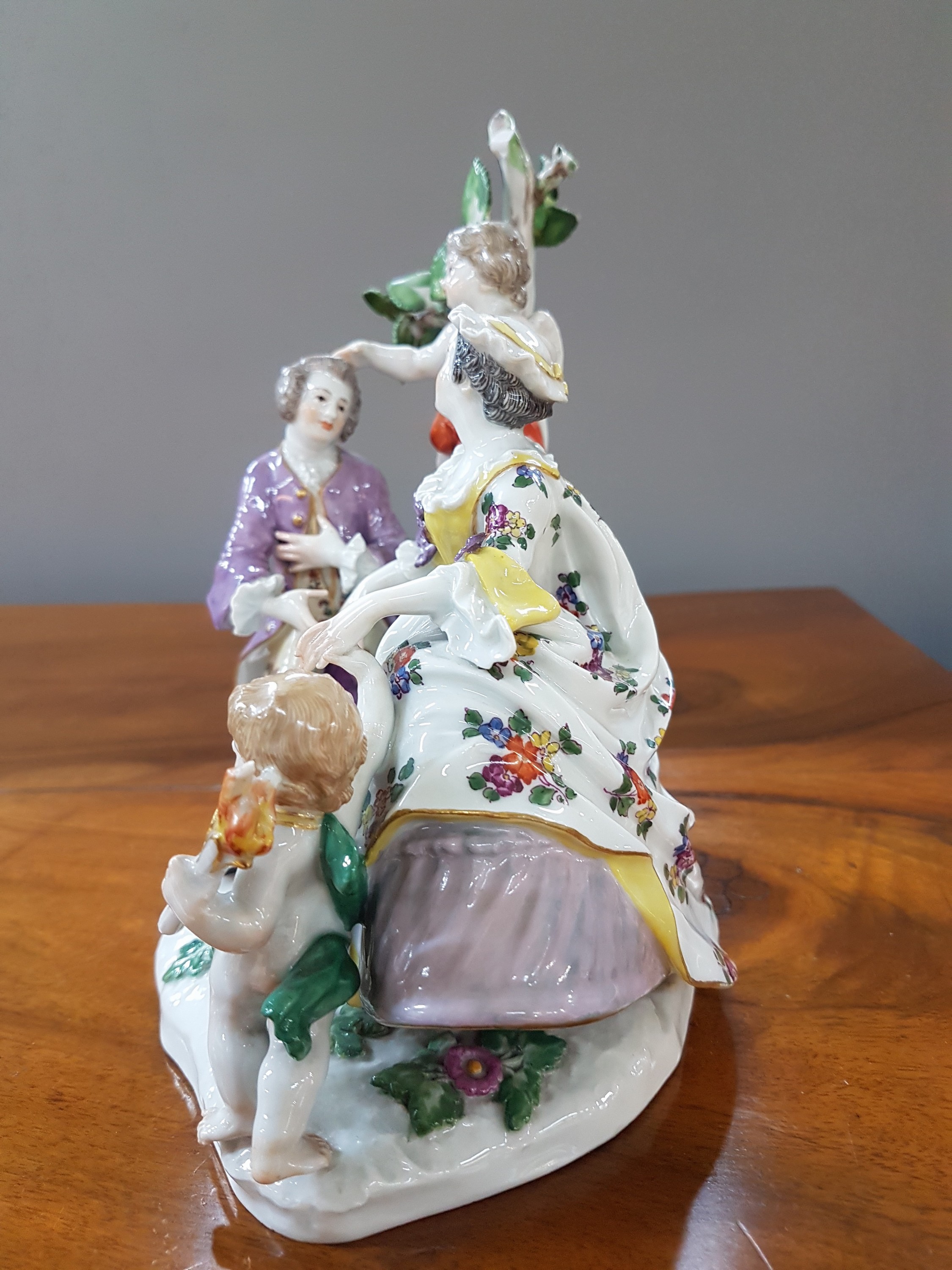 Detail b: Porzellanfigurengruppe, Meissen, um 1900, galante Szenerie mit zwei Putten, bunt bemalt, Blattwerk des Baumes bestoßen und teils fehlend, H. ca. 18cm