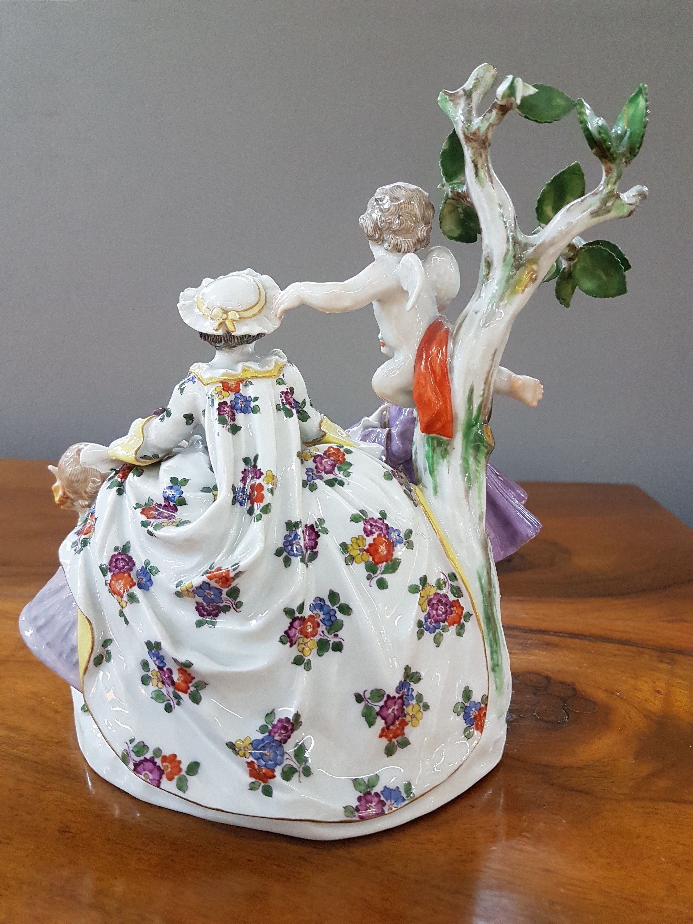 Detail c: Porzellanfigurengruppe, Meissen, um 1900, galante Szenerie mit zwei Putten, bunt bemalt, Blattwerk des Baumes bestoßen und teils fehlend, H. ca. 18cm