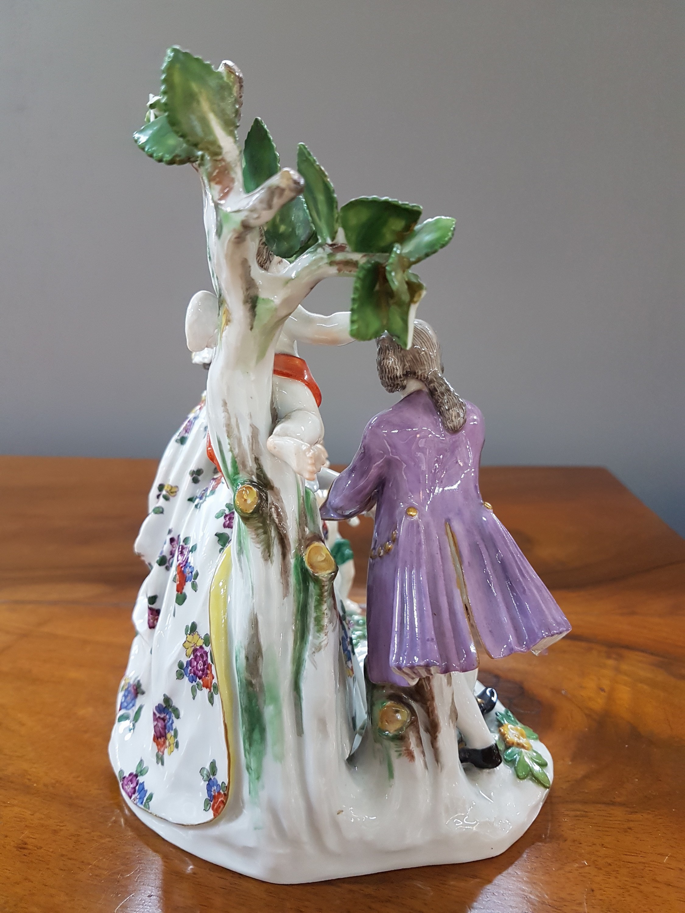Detail d: Porzellanfigurengruppe, Meissen, um 1900, galante Szenerie mit zwei Putten, bunt bemalt, Blattwerk des Baumes bestoßen und teils fehlend, H. ca. 18cm