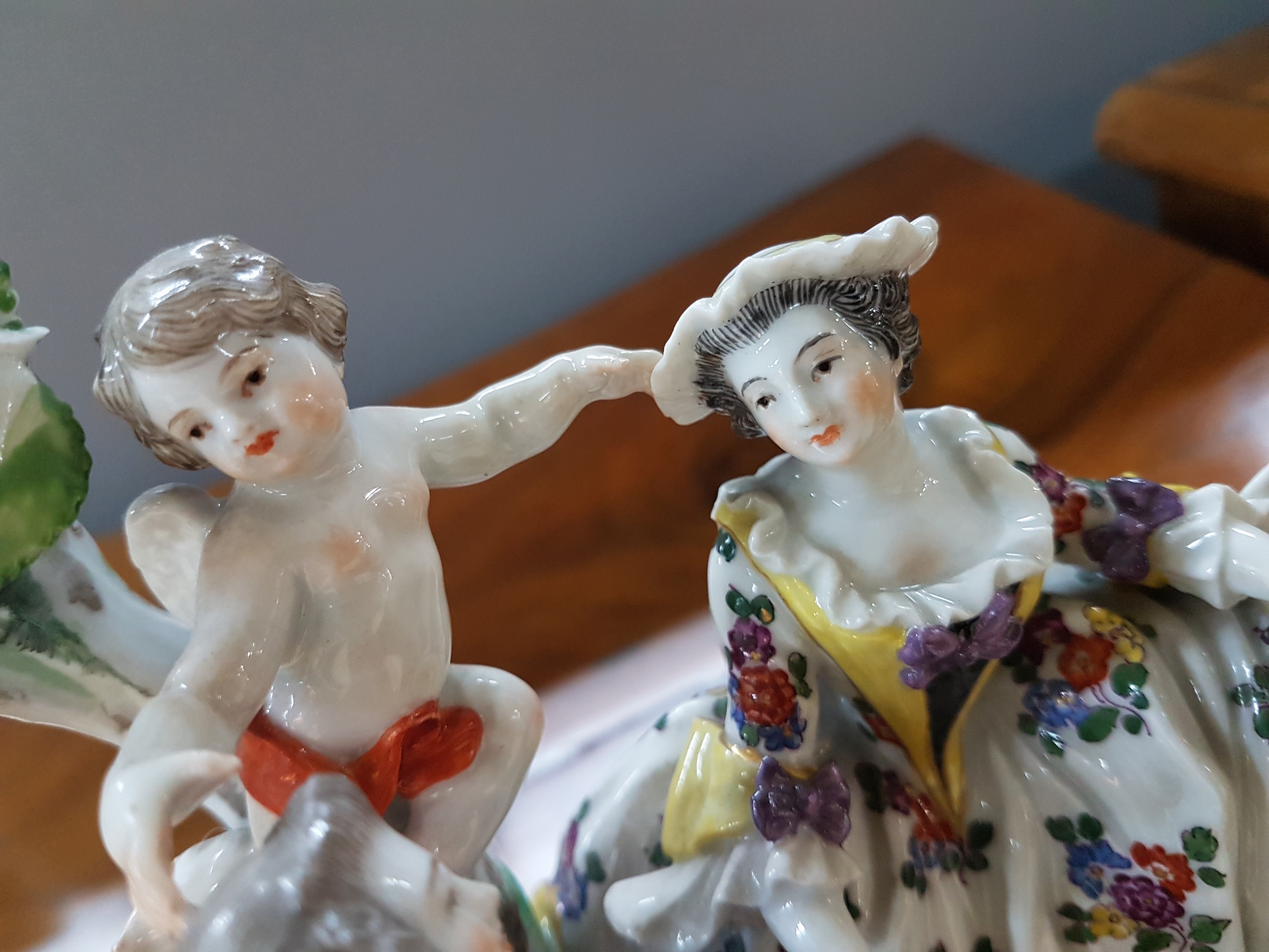 Detail e: Porzellanfigurengruppe, Meissen, um 1900, galante Szenerie mit zwei Putten, bunt bemalt, Blattwerk des Baumes bestoßen und teils fehlend, H. ca. 18cm