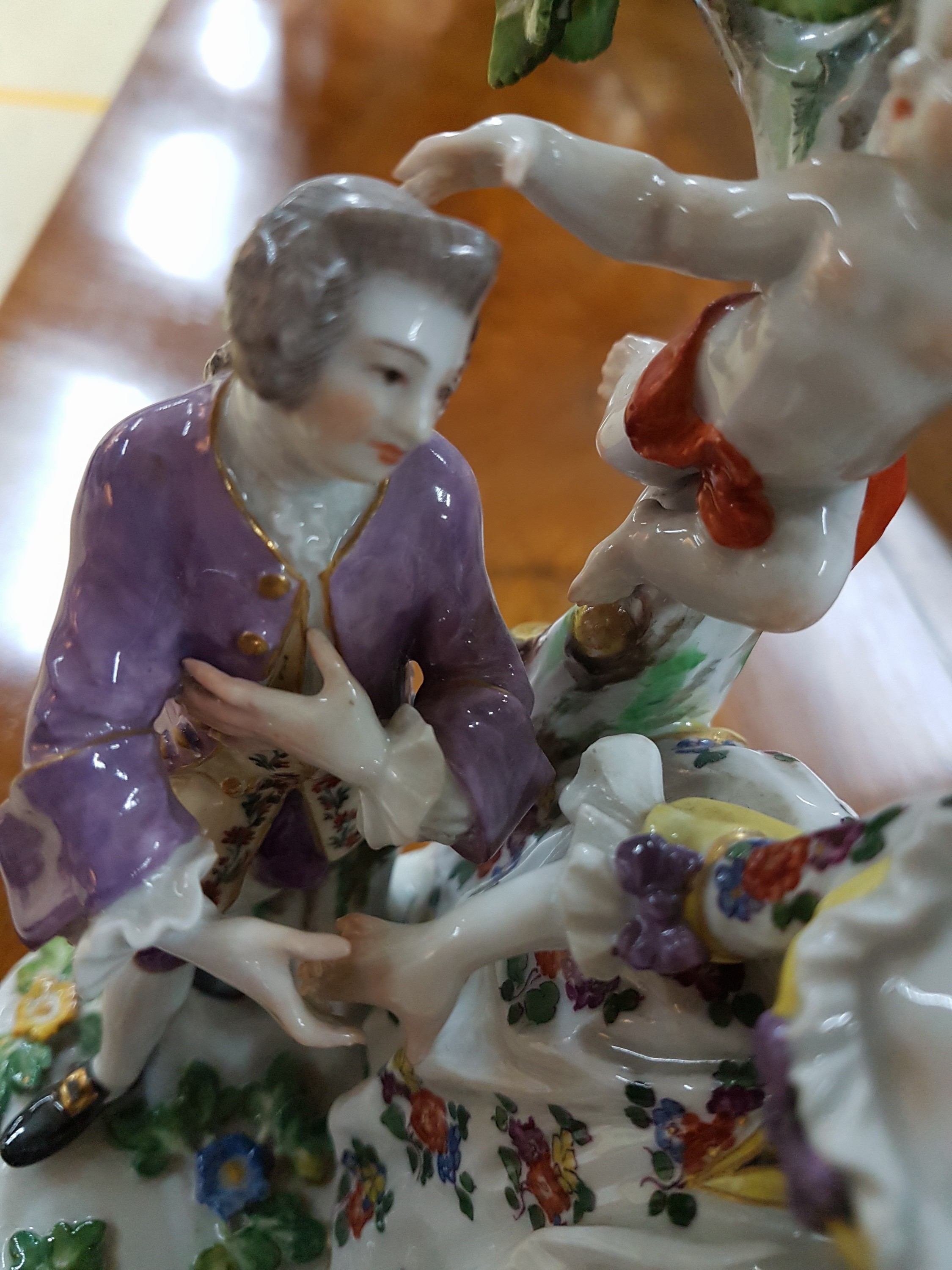 Detail g: Porzellanfigurengruppe, Meissen, um 1900, galante Szenerie mit zwei Putten, bunt bemalt, Blattwerk des Baumes bestoßen und teils fehlend, H. ca. 18cm