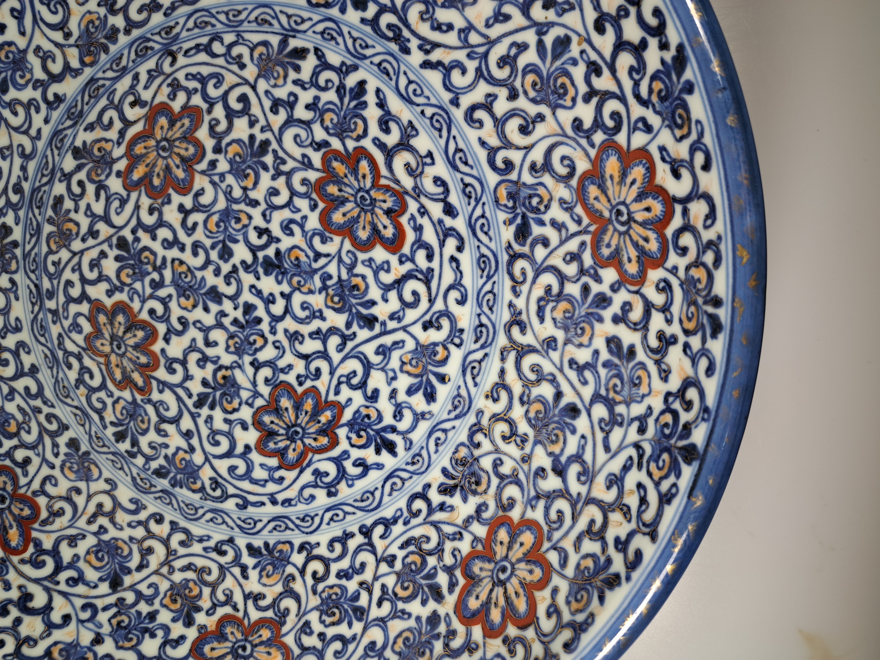 Detail d: Paar Teller, China, um 1900,, Porzellan, unterglasurblauer Dekor, Rot und Golden gehöht, Blumendekor, leicht berieben, D. 41.5 cm