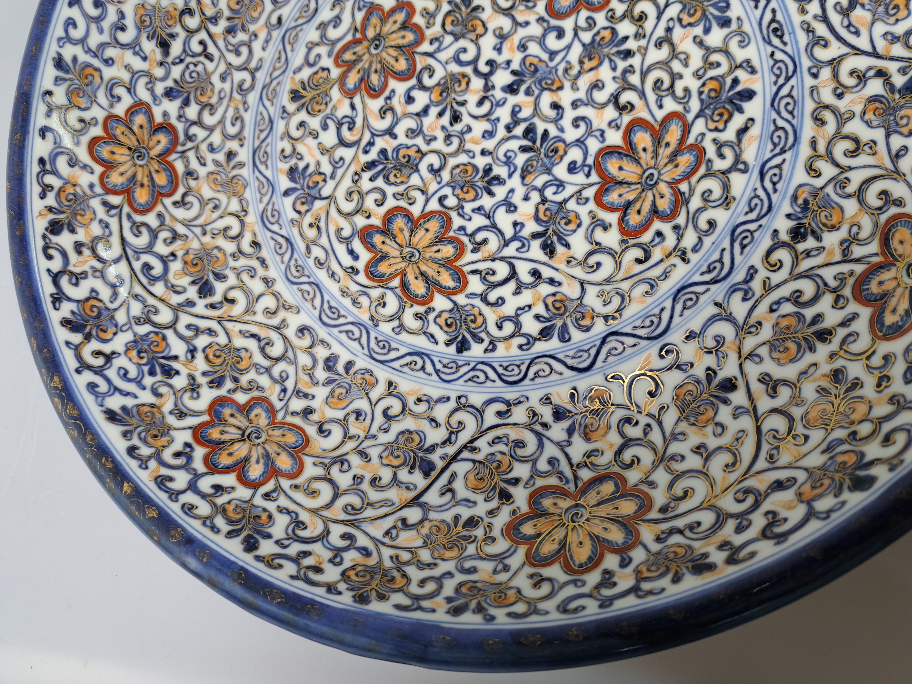 Detail j: Paar Teller, China, um 1900,, Porzellan, unterglasurblauer Dekor, Rot und Golden gehöht, Blumendekor, leicht berieben, D. 41.5 cm