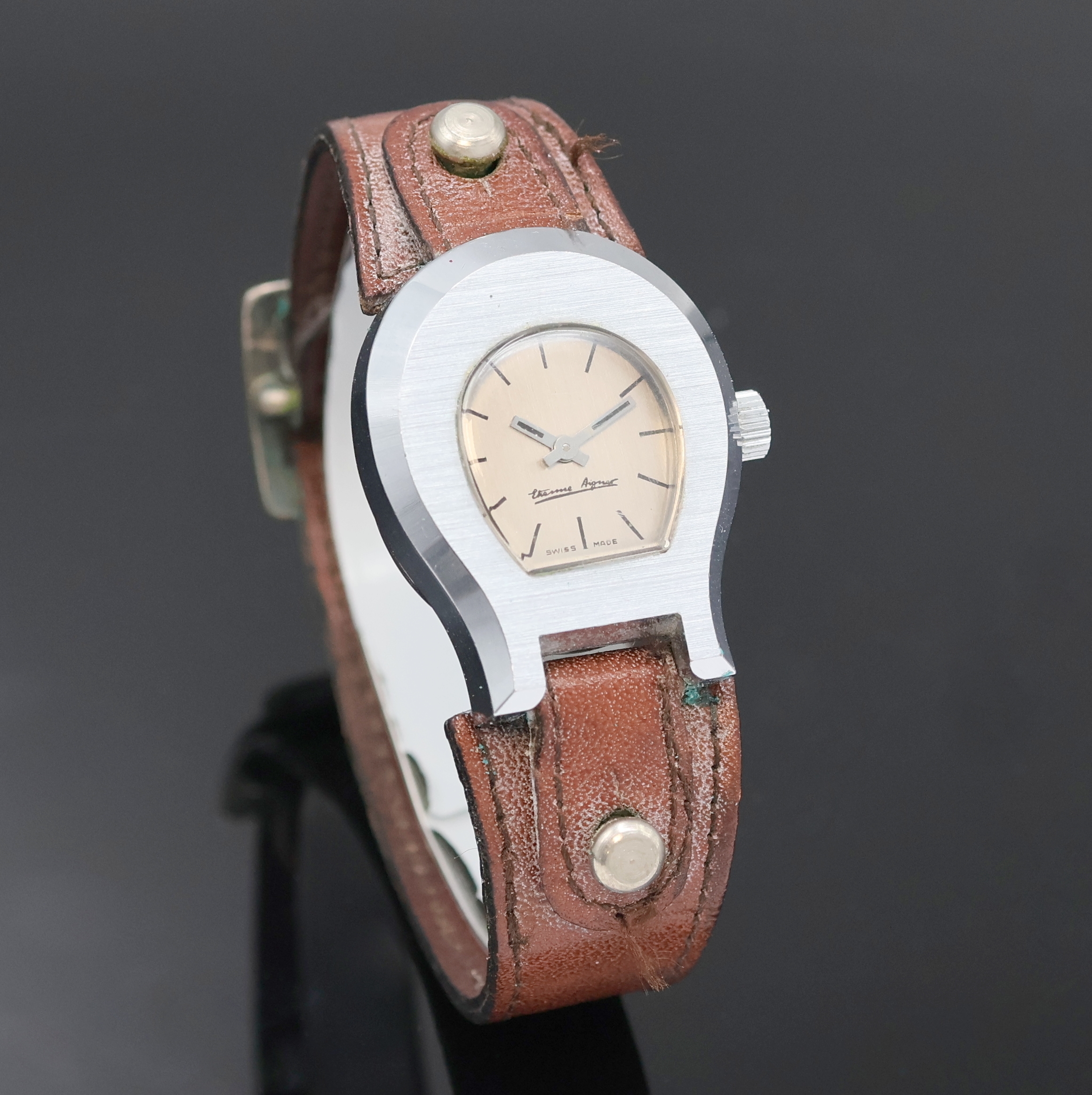 Detail b: ETIENNE AIGNER Damenarmbanduhr, Schweiz um 1980, Handaufzug, verchr. Geh. im Aigner Logo, Edelstahlboden aufgedr., orig. Lederband m. orig. ...