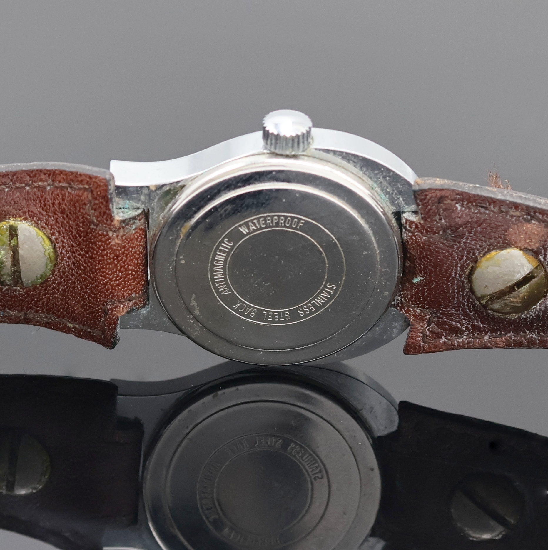 Detail e: ETIENNE AIGNER Damenarmbanduhr, Schweiz um 1980, Handaufzug, verchr. Geh. im Aigner Logo, Edelstahlboden aufgedr., orig. Lederband m. orig. ...