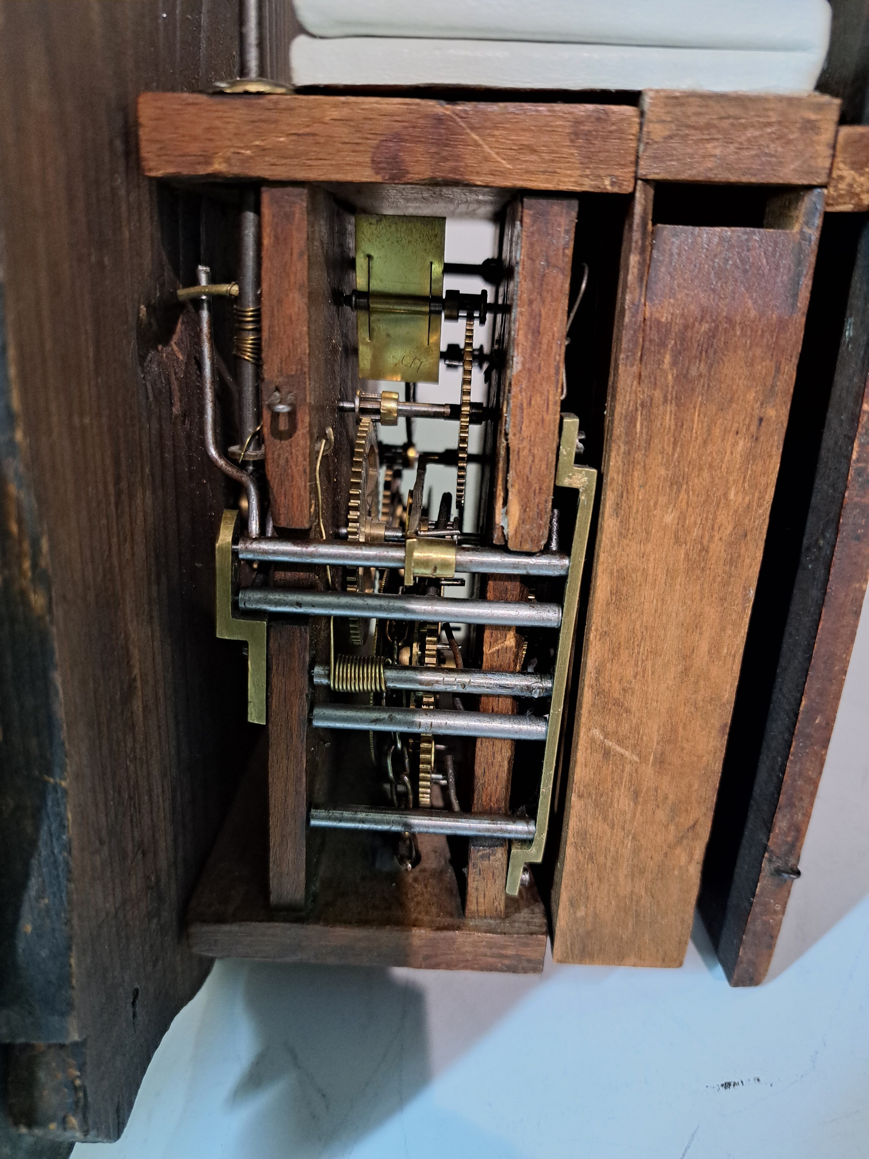 Detail e: Seltene Kuckucksuhr, Schwarzwald um 1880, Blechschild auf Holz, Jagdgesellschaft, darüber Türe für Kuckuck, Holzplatinenwerk, stehende Pfeifen, ...