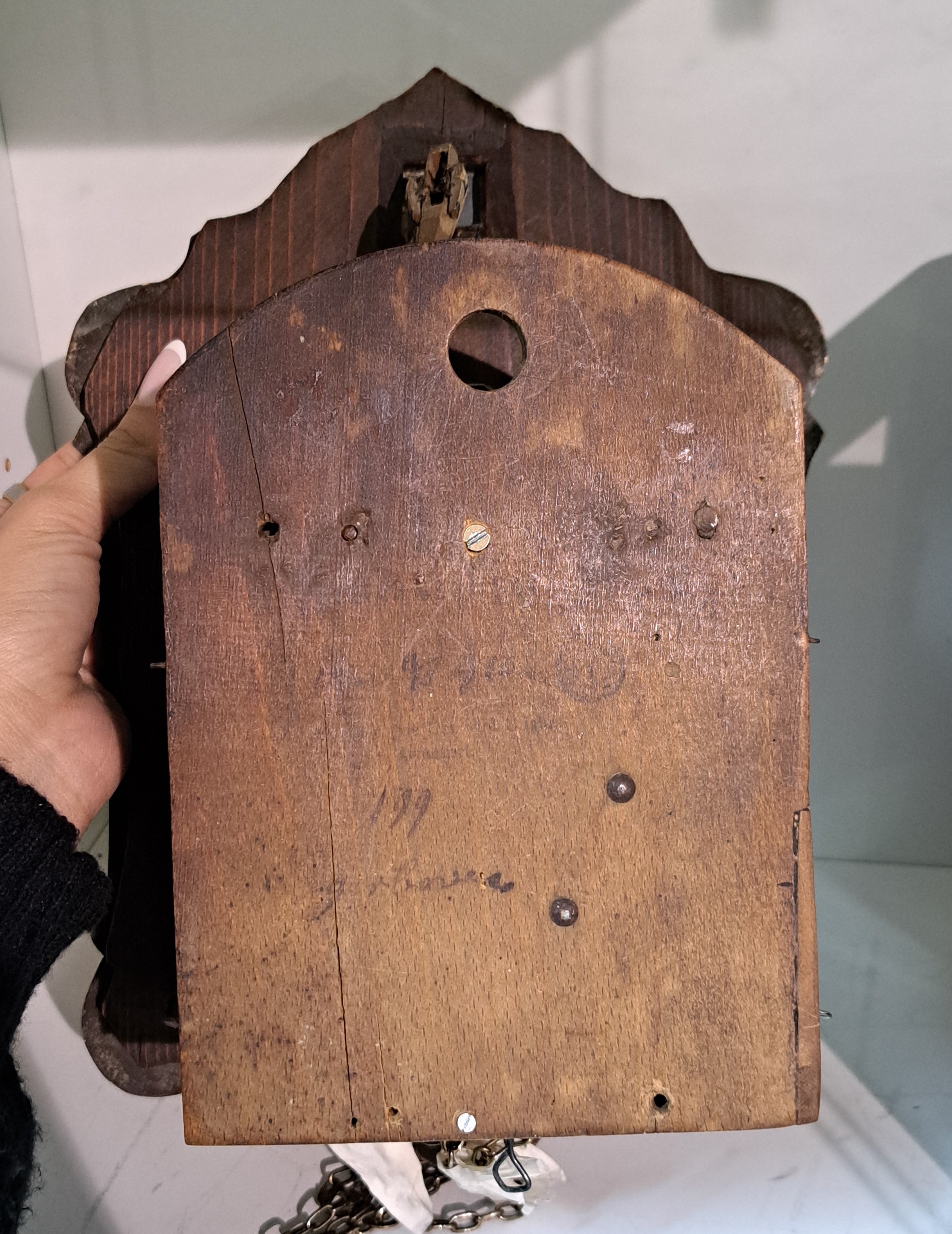 Detail f: Seltene Kuckucksuhr, Schwarzwald um 1880, Blechschild auf Holz, Jagdgesellschaft, darüber Türe für Kuckuck, Holzplatinenwerk, stehende Pfeifen, ...