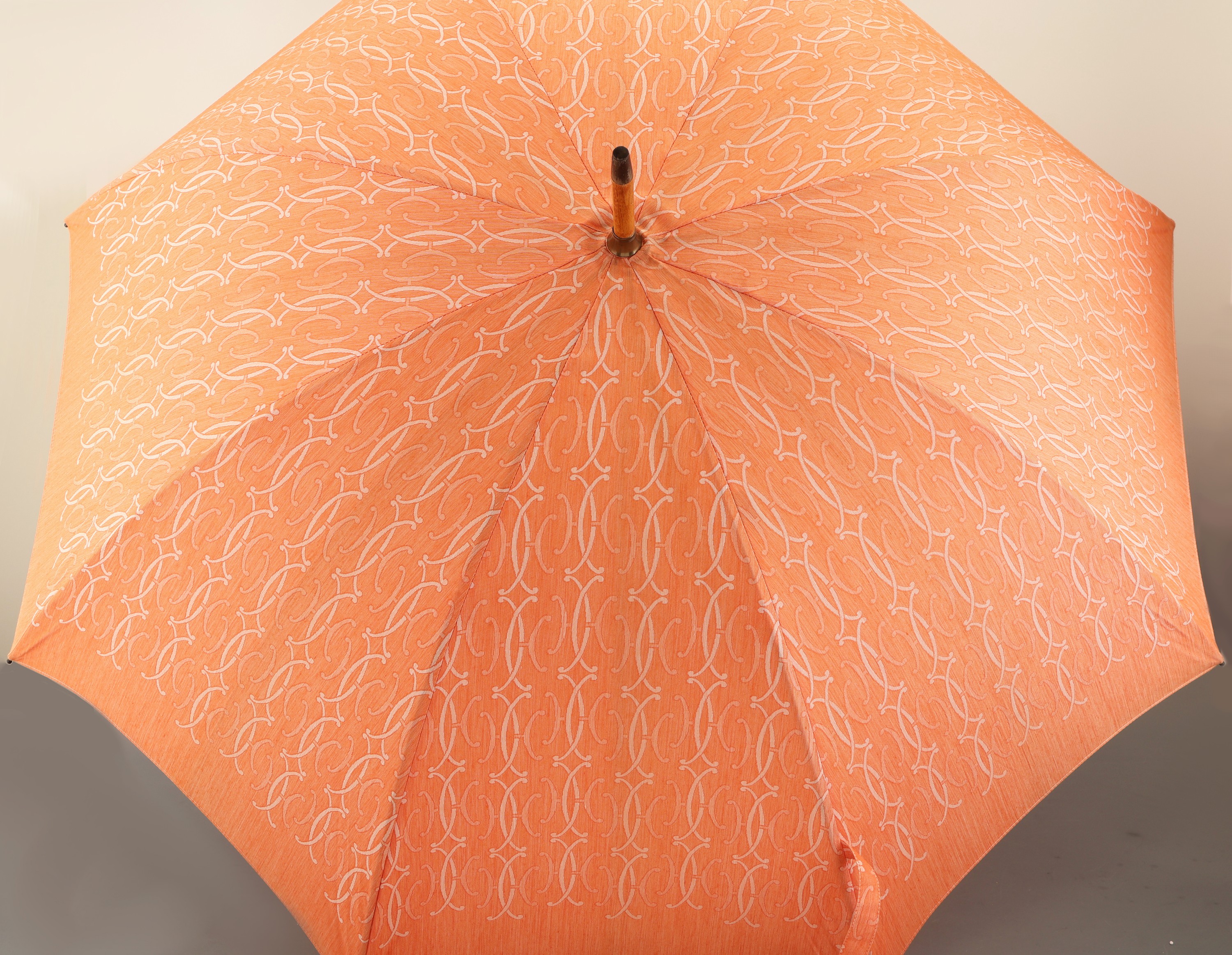 Detail a: HERMES Schirm, Paris, lachsfarb. mit H Emblemen, Holzrahmen, Messingdetails, L. ca. 89 cm, D. im aufgeklappten Zustand ca. 96 cm