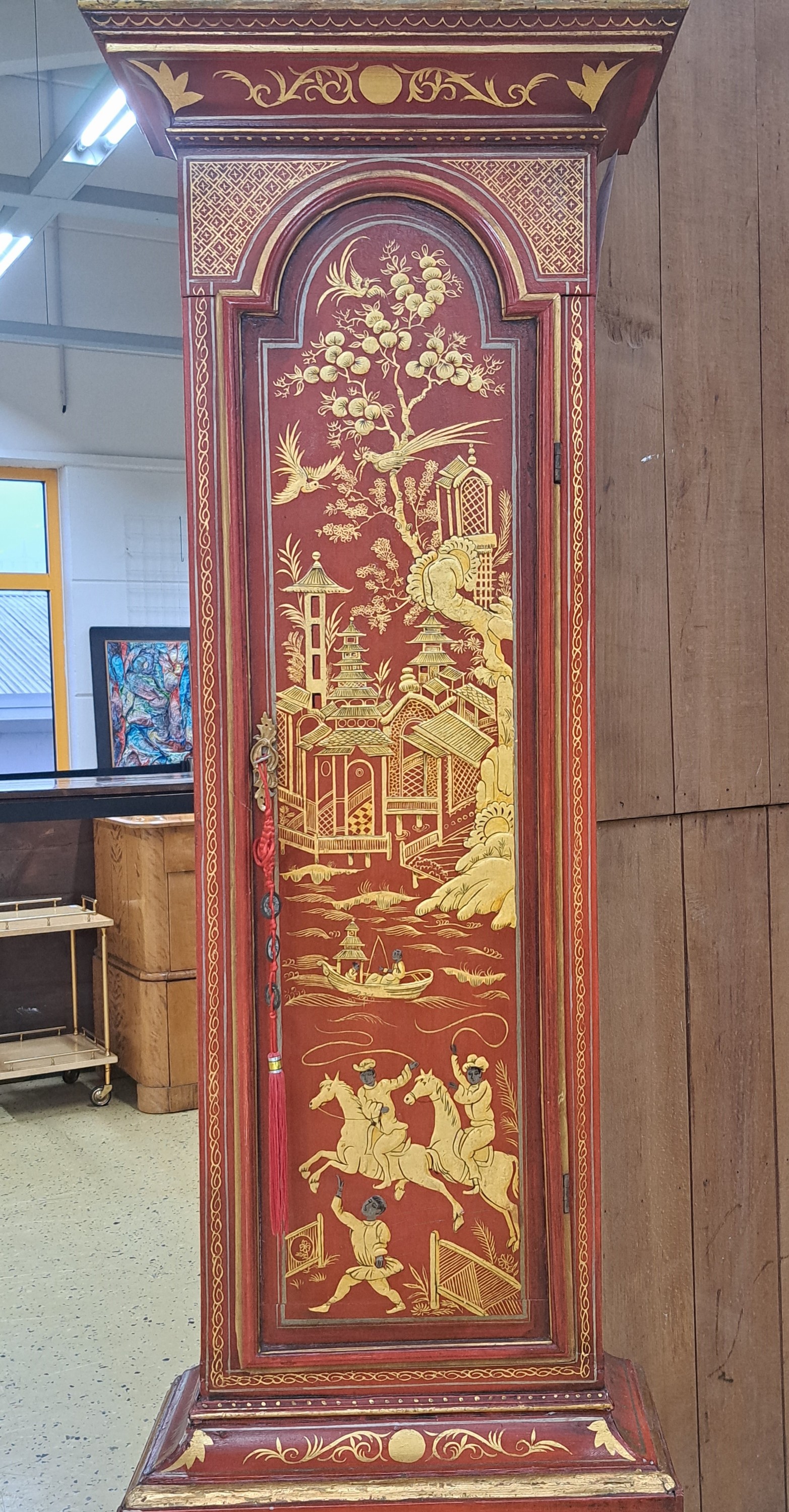 Detail b: Standuhr, England, Ende 18. Jh., einteiliges Holzgehäuse, farblich gefaßt in Chinoiserie, durchgehende Rückwand (spannungsrissig), roter Grundton ...