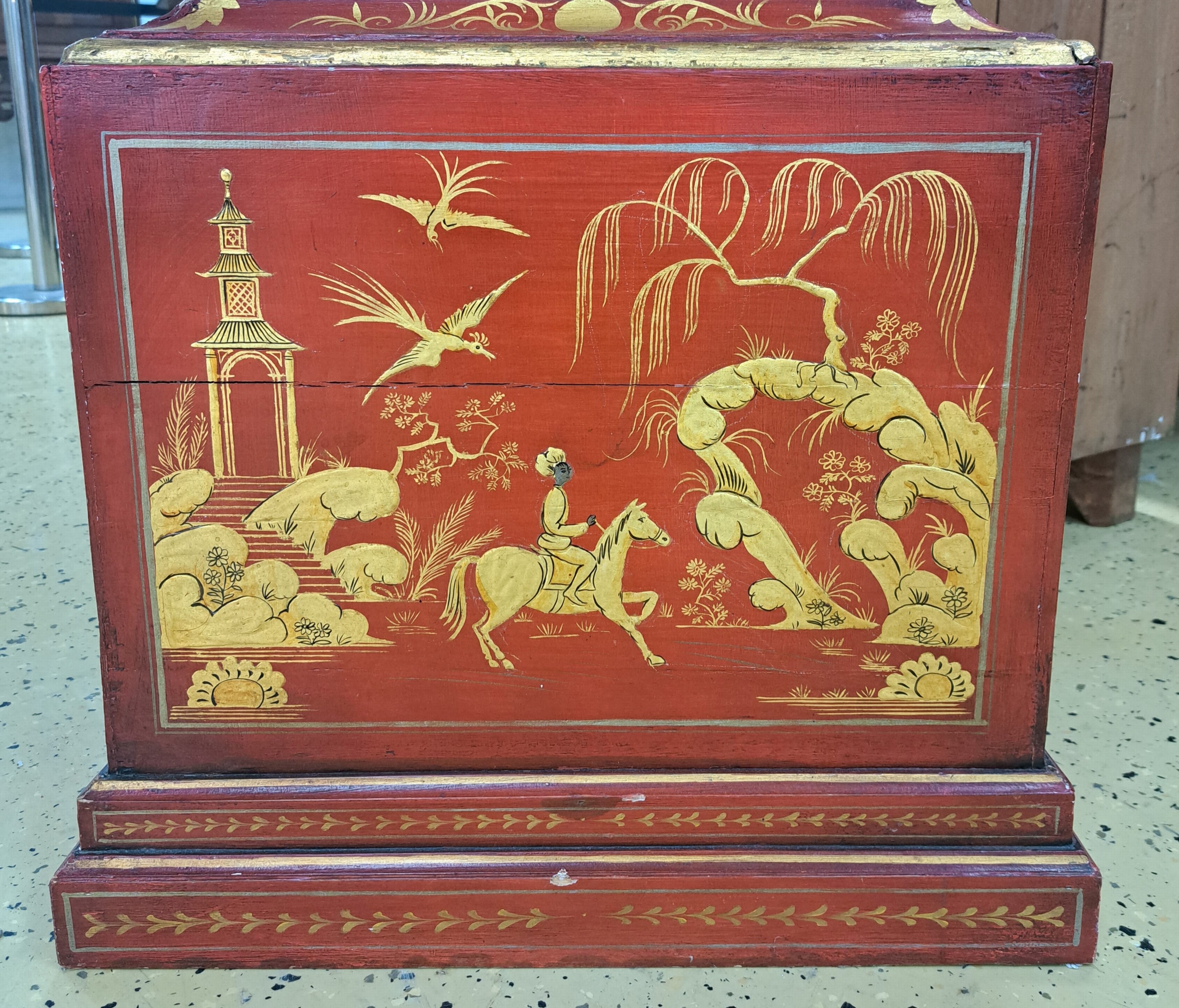 Detail c: Standuhr, England, Ende 18. Jh., einteiliges Holzgehäuse, farblich gefaßt in Chinoiserie, durchgehende Rückwand (spannungsrissig), roter Grundton ...