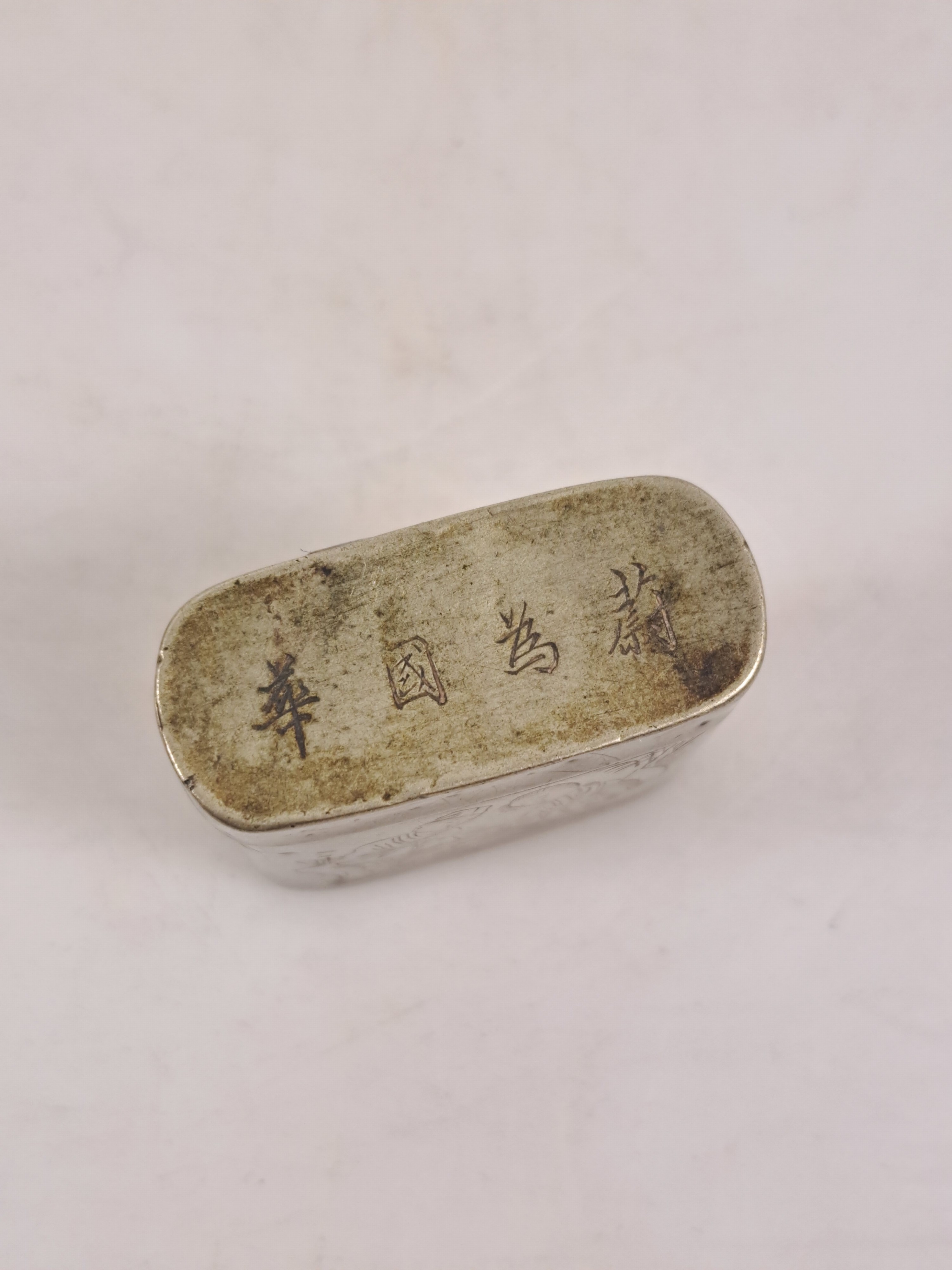 Detail e: Opiumdose, Tintendose und Deckeldose aus China, Metall versilbert, z.T. mit Schriftzeichen; Opiumdose mit graviertem Paar dekoriert, H. ca. 4 cm; ...