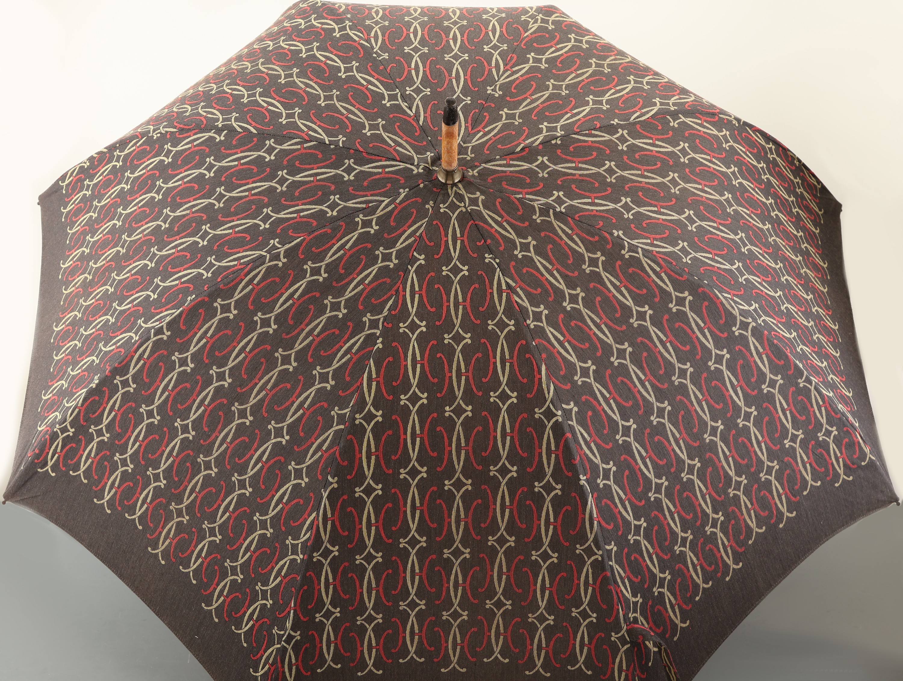 Detail a: HERMES Schirm, Paris, schwarz mit gelben und roten H Emblemen, Holzrahmen, Messingdetails, L. ca. 89 cm, D. im aufgeklappten Zustand ca. 96 cm