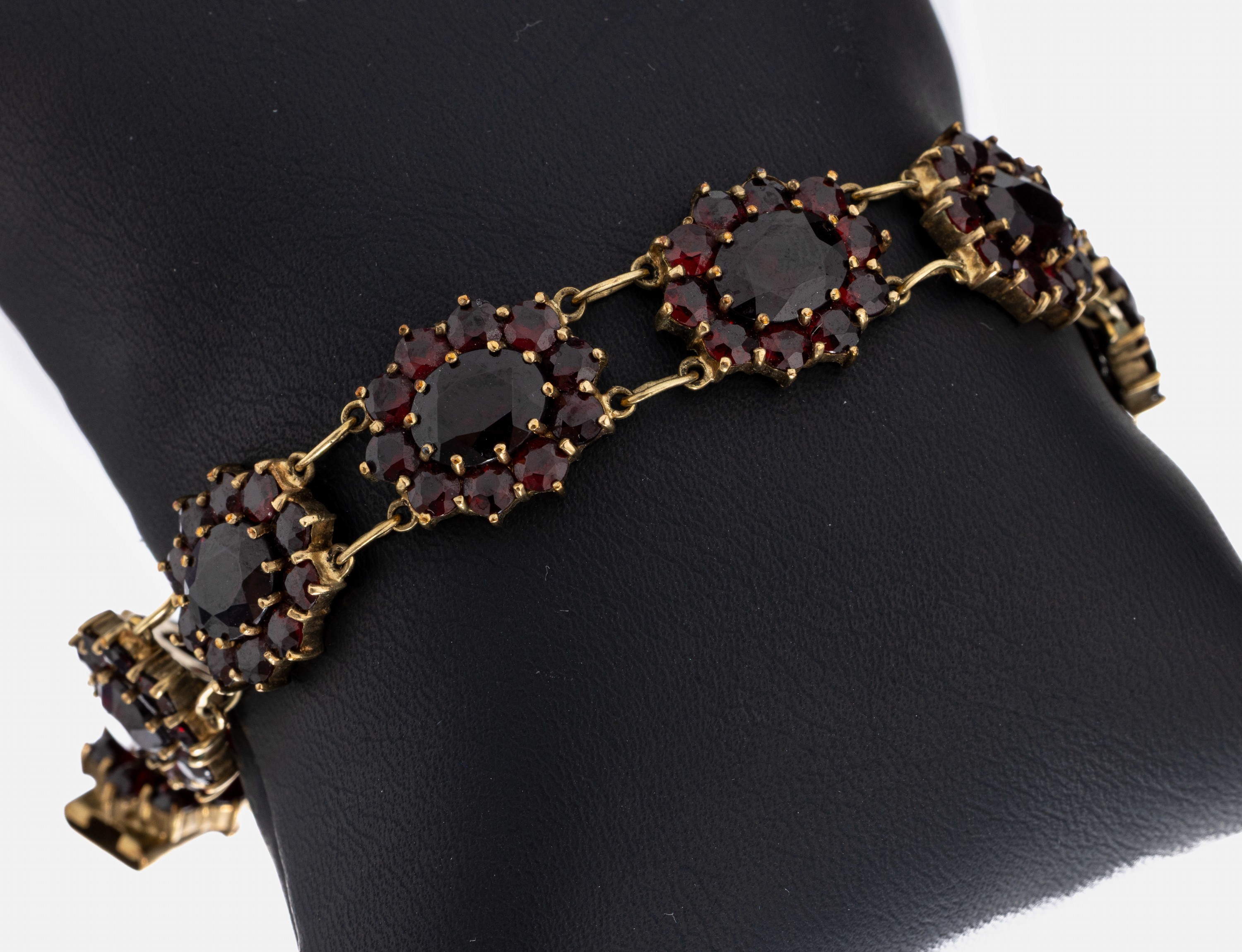8 kt Gold Granat-Armband, GG 333/000, ovaleblütenf. Glieder, facett. Granate, L. ca. 20 cm, Kastenschloss mit Sicherheitsacht, ca. 23.2 g