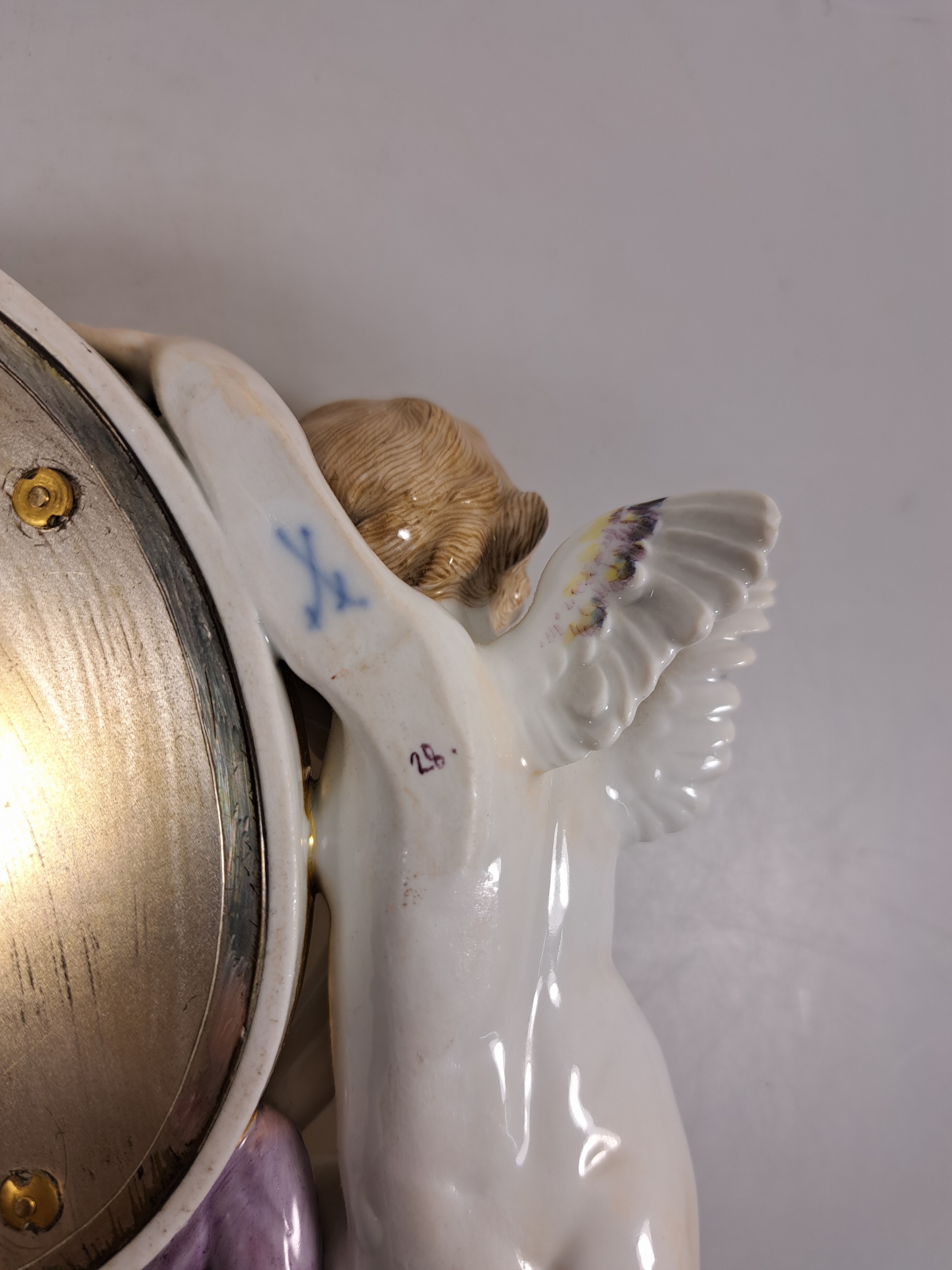 Detail g: Wandspiegel mit Amorette, Meissen um 1900, Porzellan, Amorette mit lilafarbener Schärpe hält eine ovalen Spiegel, applizierte Blüten, polychrom ...
