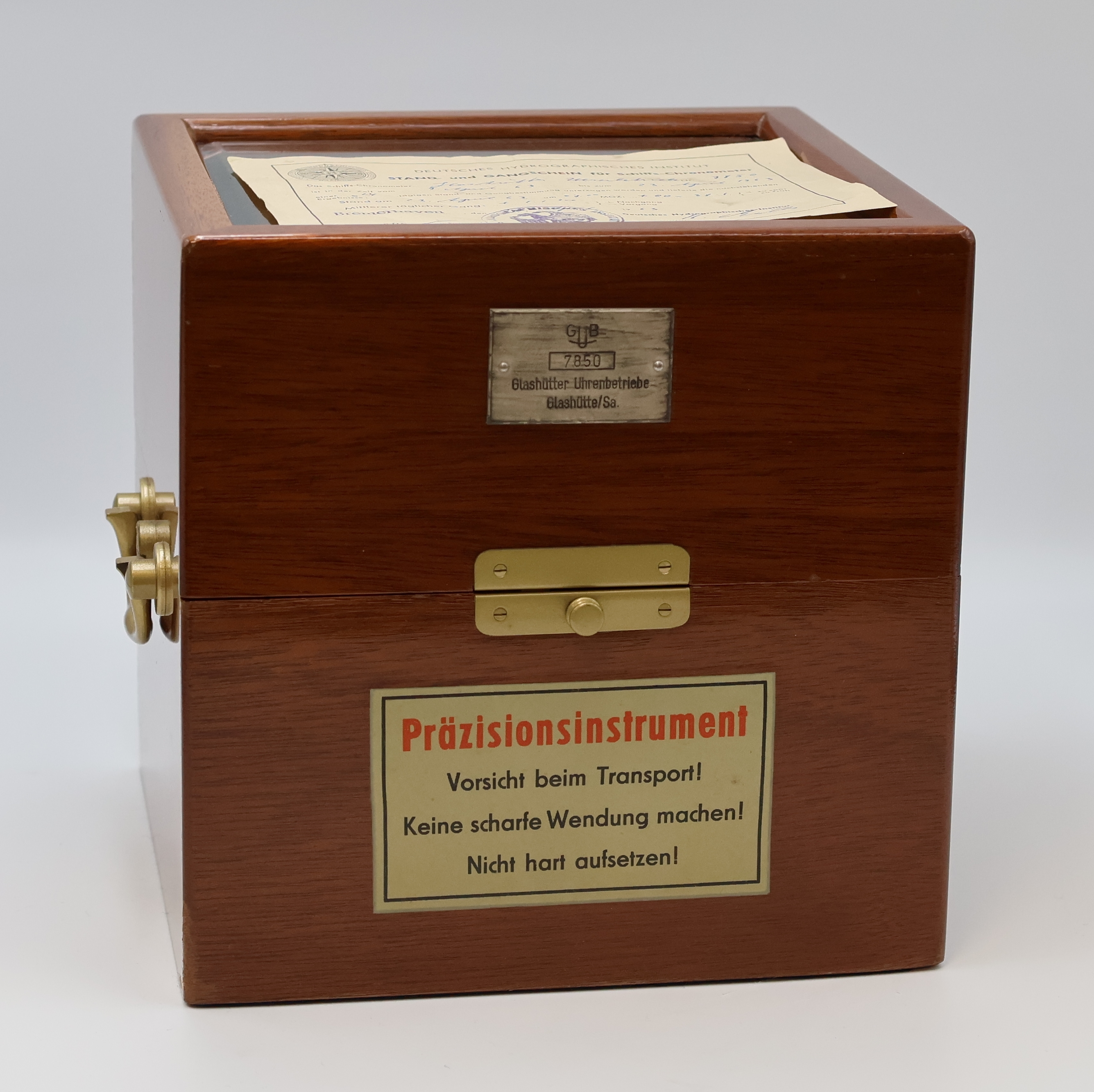 Detail a: GUB Marinechronometer mit original Transportbox und Gangschein, DDR um 1963, 2 -tlg. facett-vergl. Mahagoni-Box, seitl. Tragegriffe, kardanisch ...