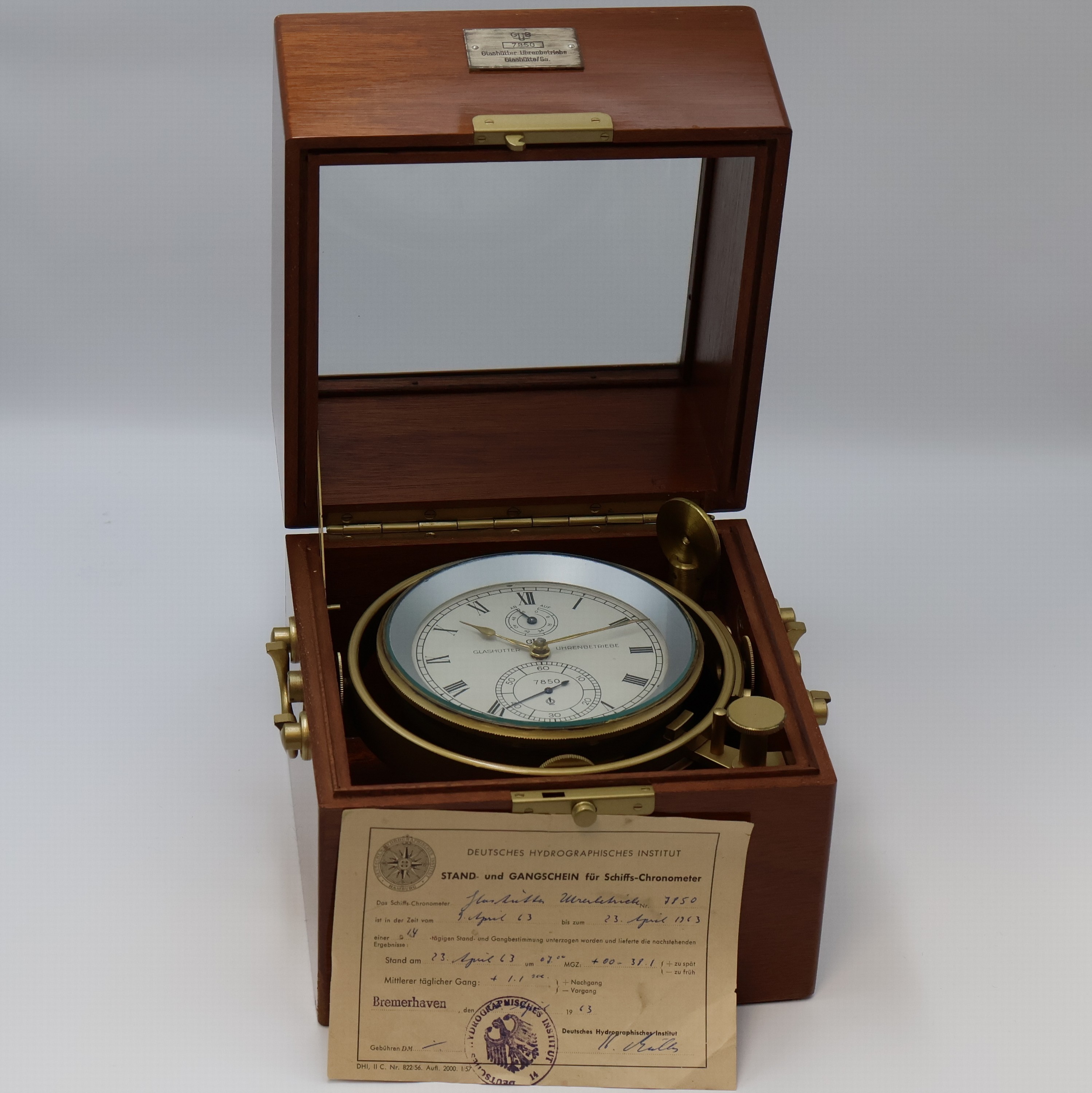 Detail b: GUB Marinechronometer mit original Transportbox und Gangschein, DDR um 1963, 2 -tlg. facett-vergl. Mahagoni-Box, seitl. Tragegriffe, kardanisch ...