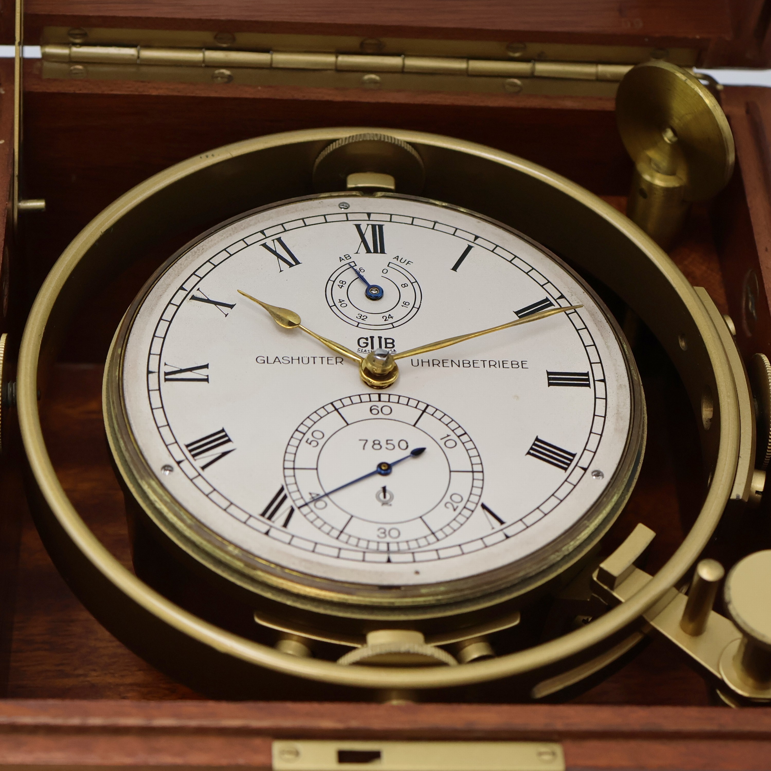 Detail c: GUB Marinechronometer mit original Transportbox und Gangschein, DDR um 1963, 2 -tlg. facett-vergl. Mahagoni-Box, seitl. Tragegriffe, kardanisch ...